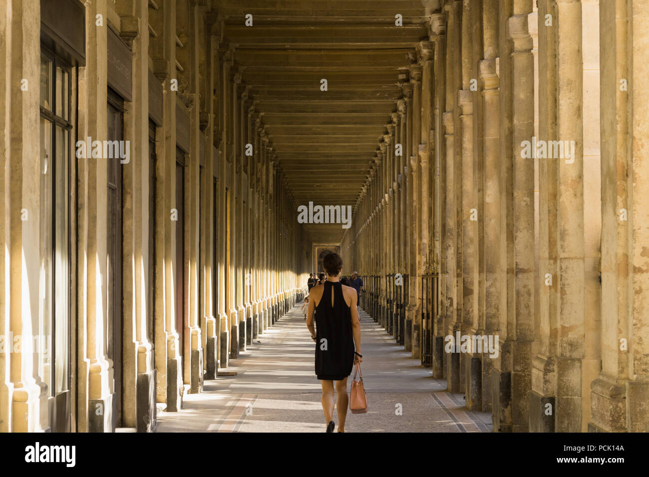 Palais Royal Paris - die Frau, die zu Fuß entlang der Galerie de Beaujolais im Palais Royal in Paris, Frankreich, Europa. Stockfoto