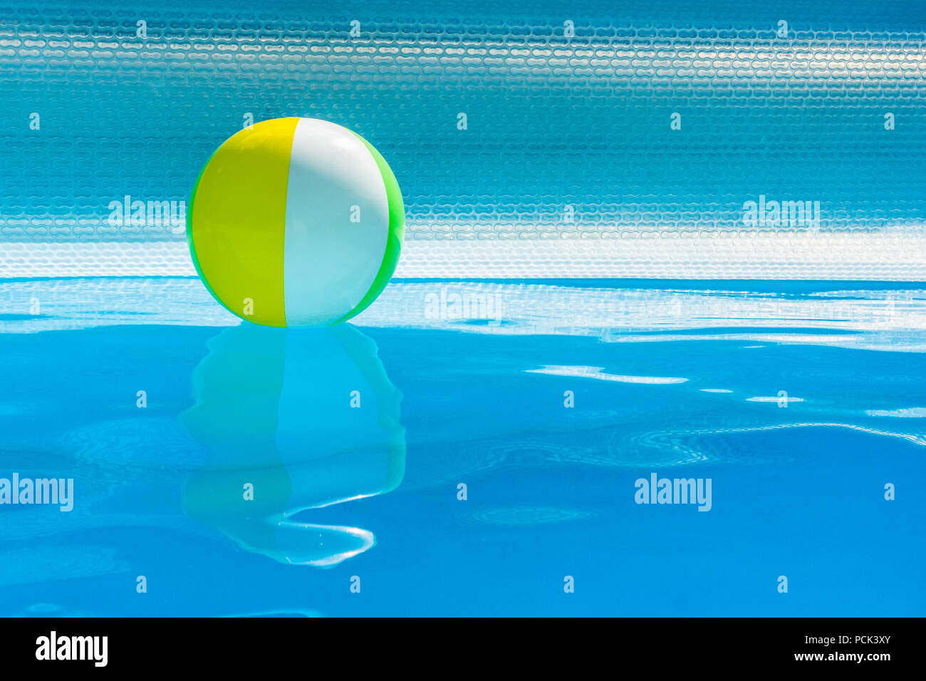 Aufblasbare bunte Kugel schweben auf Schwimmbadwasser, mit Kopie Raum, Sommer, Freizeit Konzept. Stockfoto