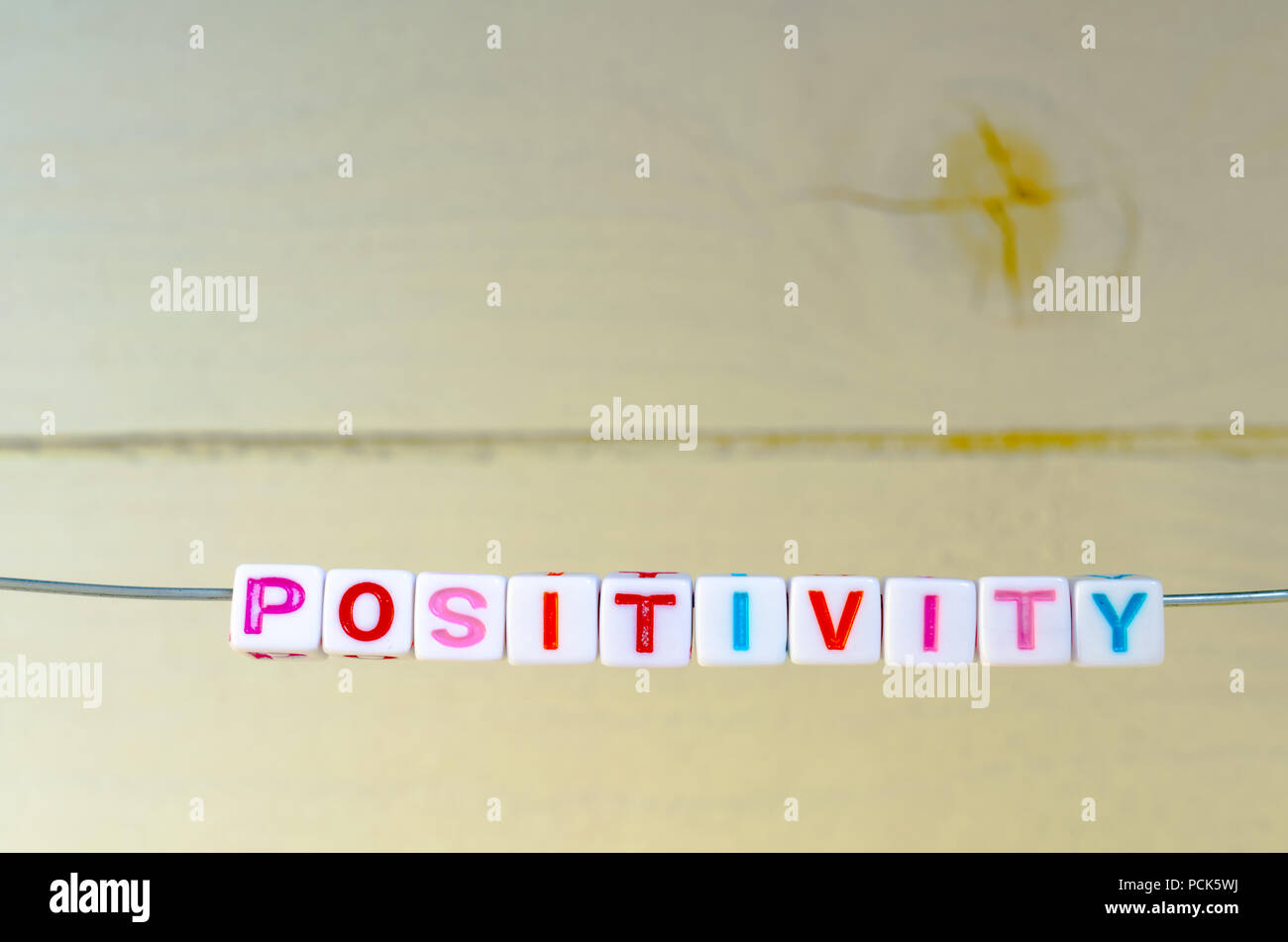 Ein Studio Foto von Alphabetisch Perlen auf einem Draht Schreibung 'Positivität' Stockfoto