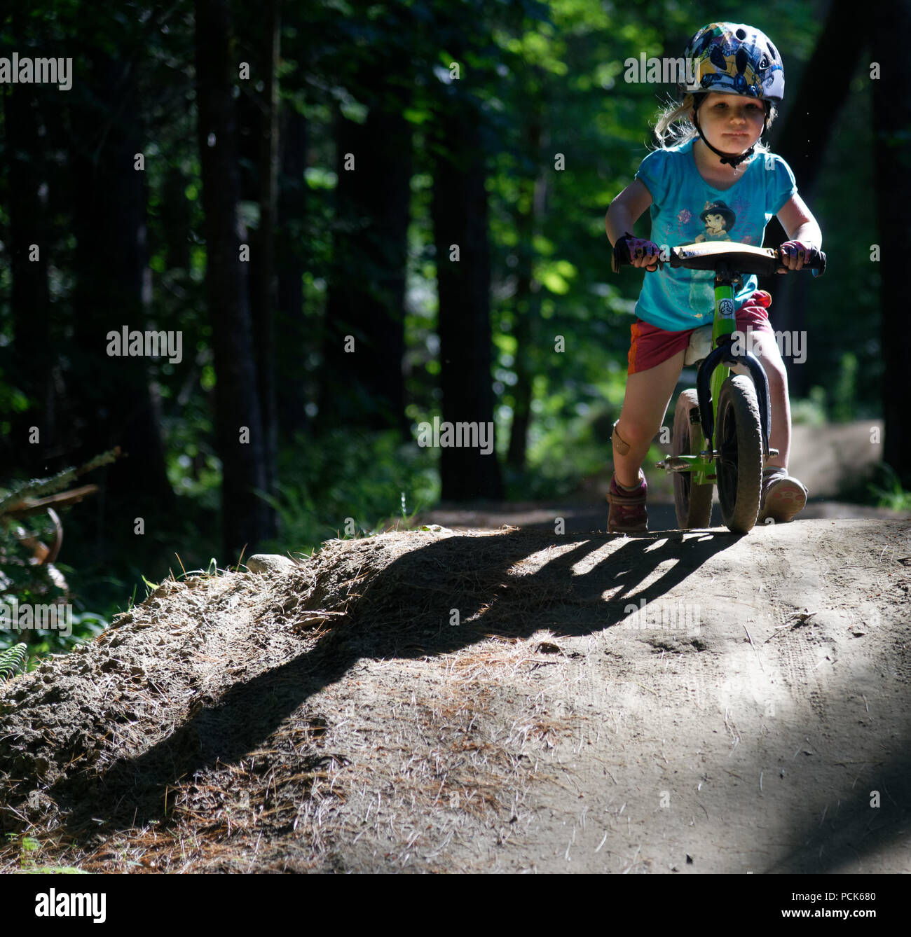 Ein kleines Mädchen (3 Jahre alt) Reiten ihr Gleichgewicht Bike im Königreich Trails atEast Burke, Vermont, USA Stockfoto