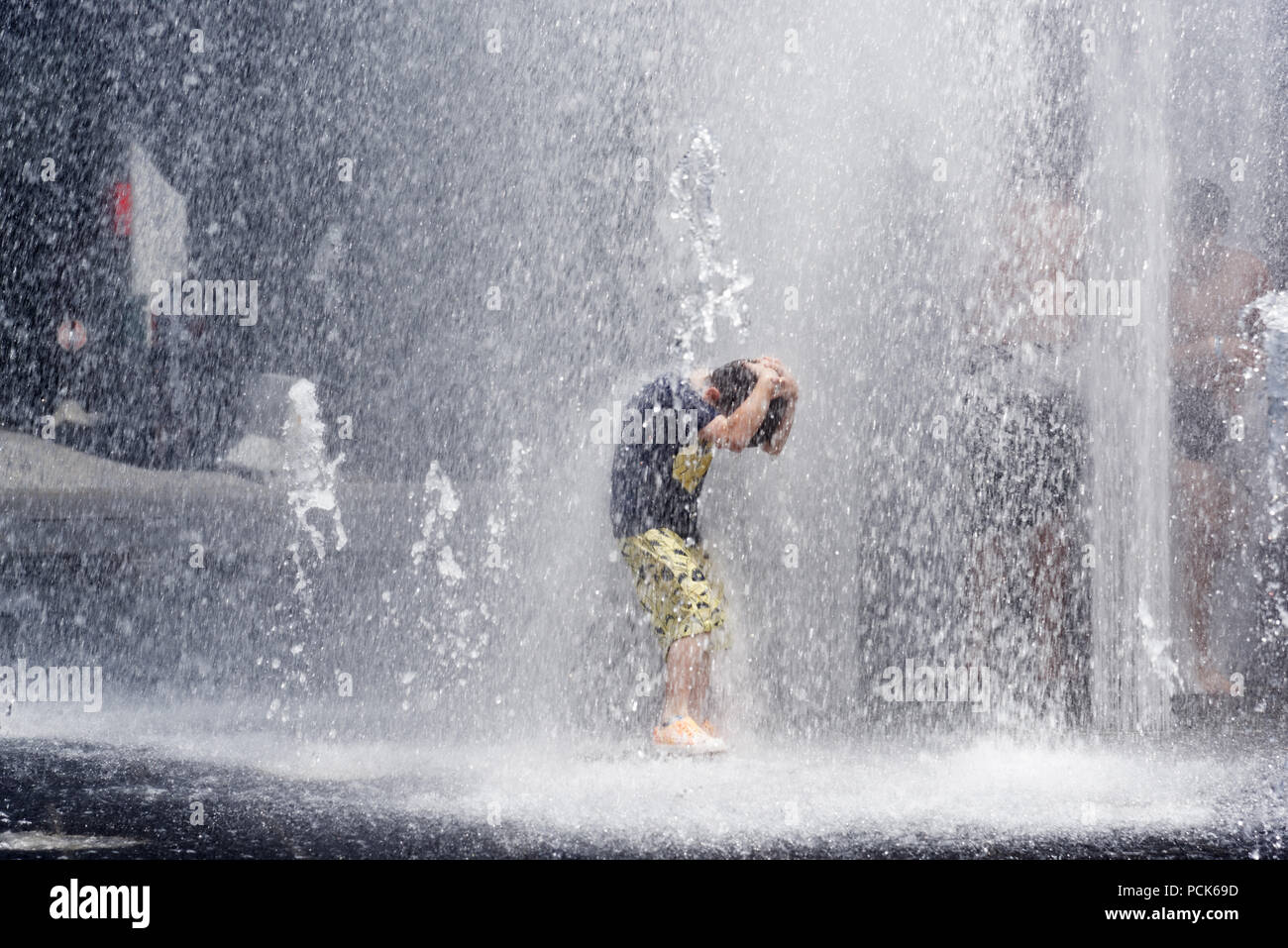 Kinder Abkühlung in Wasser Brunnen in der Rue Jeanne Mance in Montreals Entertainment District. Während der Hitzewelle 2108 genommen. Stockfoto