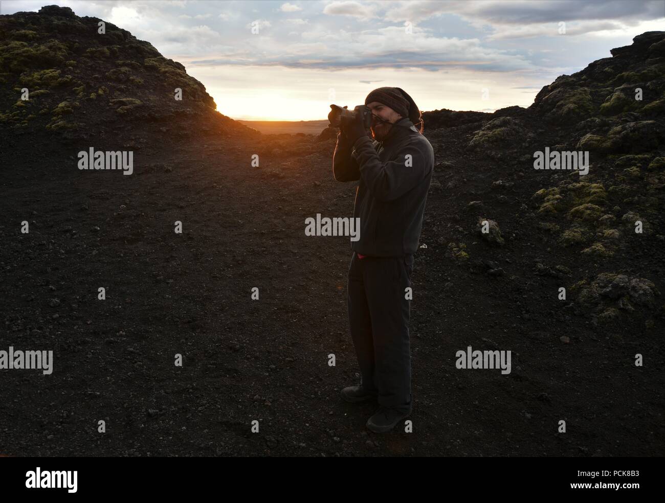 Eine abenteuerliche Fotograf klettert Krafla Vulkan und Fotos von lava Ruinen im Sonnenuntergang Stockfoto