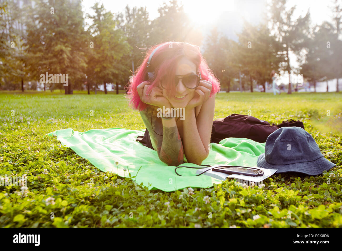 Fröhliche informellen Frau mit Musik auf Gras Stockfoto