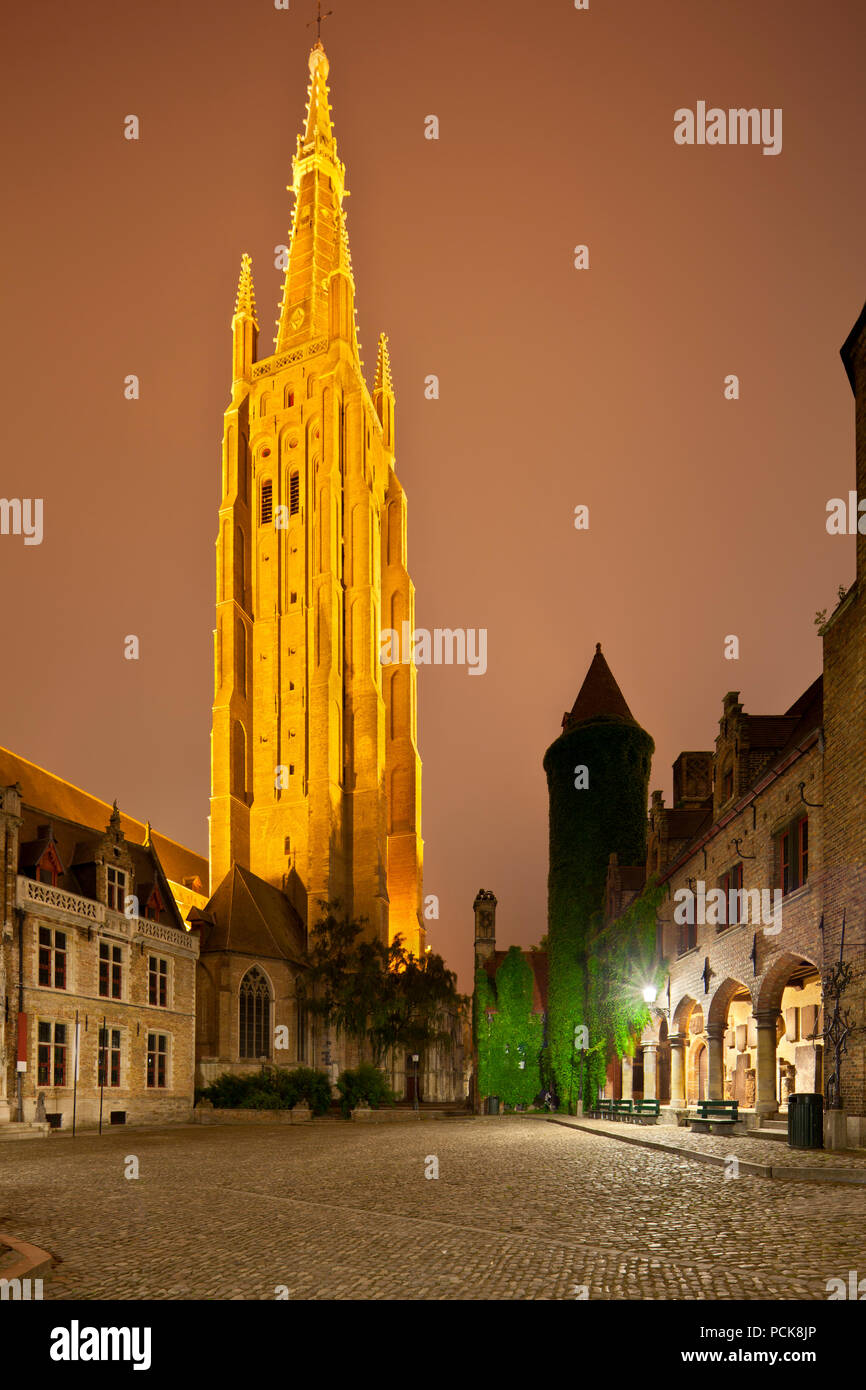 Blick auf die beleuchtete Turm der Liebfrauenkirche in Brügge in der Nacht mit dem Gruuthuse Museum Gebäude als Vordergrund. Perspektive vi korrigiert Stockfoto