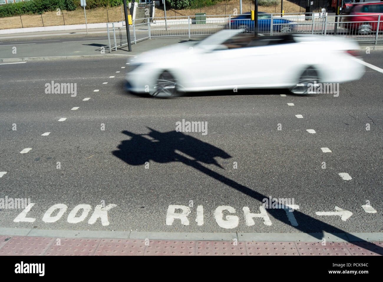 Der Schatten der Ampel, der quer durch einen Blick nach rechts weg kennzeichnen als ein weißes Auto geht, Isleworth, Middlesex, England Stockfoto