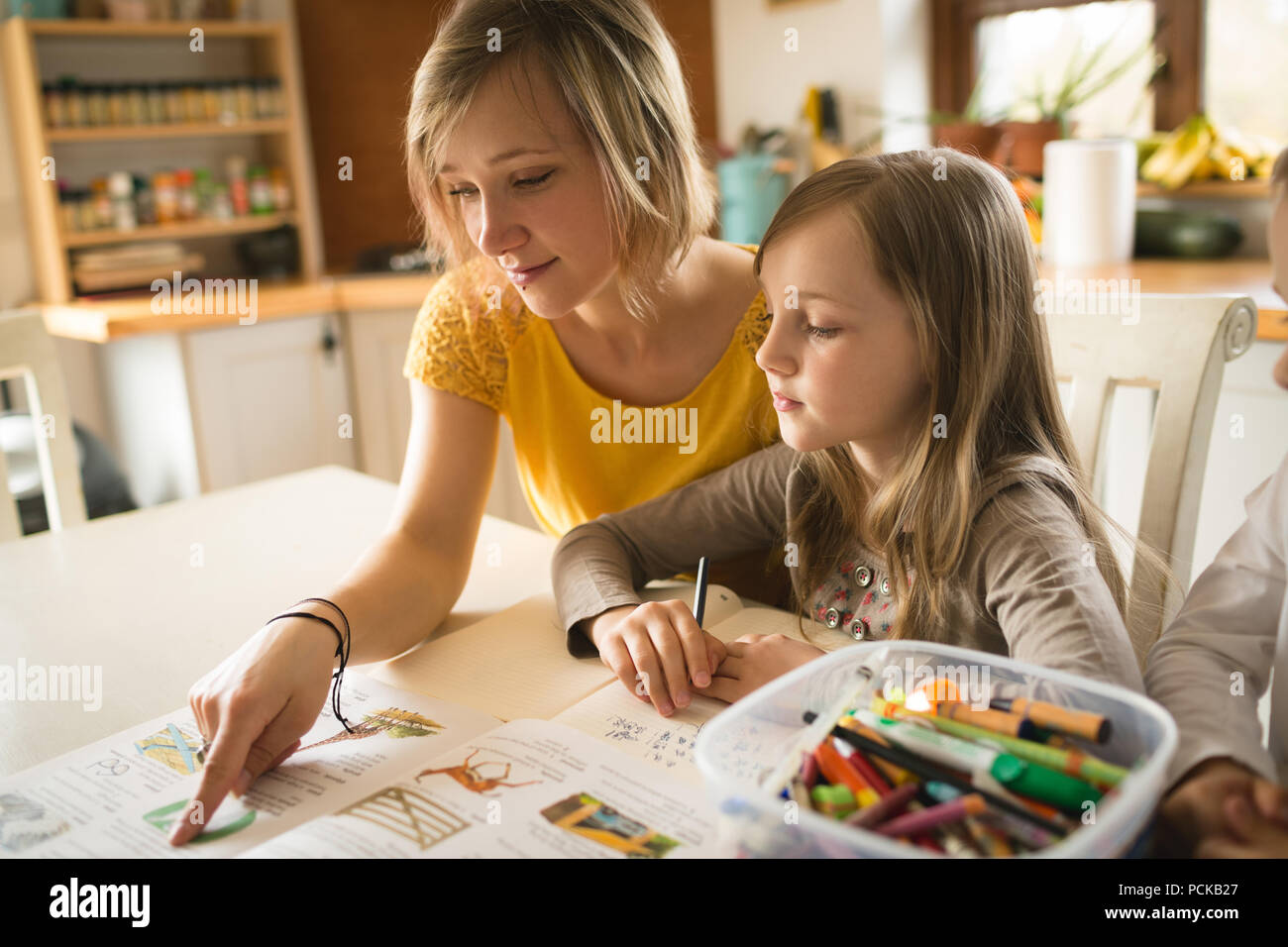 Mutter Tochter helfen bei den Hausaufgaben in der Küche Stockfotografie - Alamy