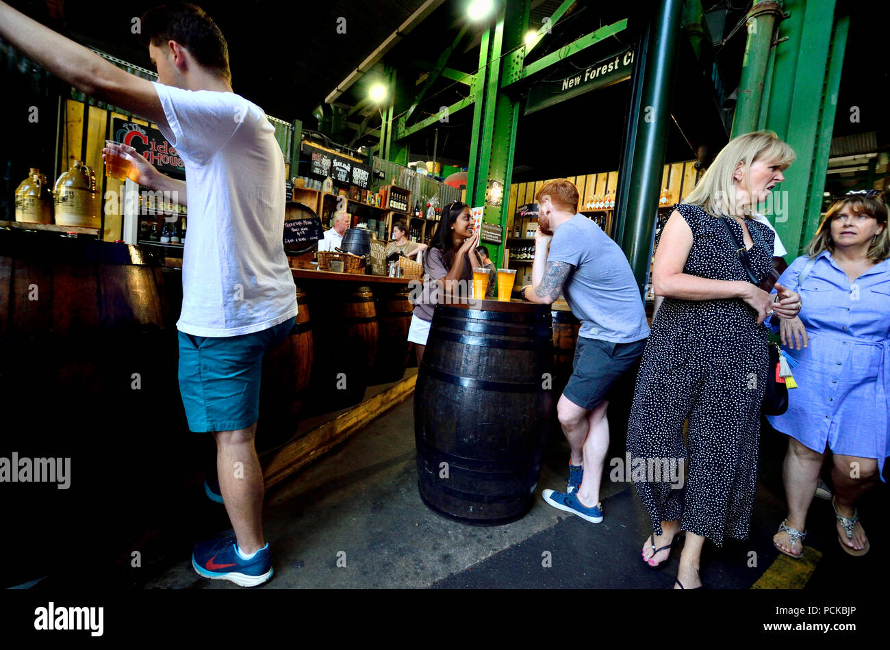 Junges Paar mit einem Drink im Borough Markt, Southwark, London, England, UK. Stockfoto