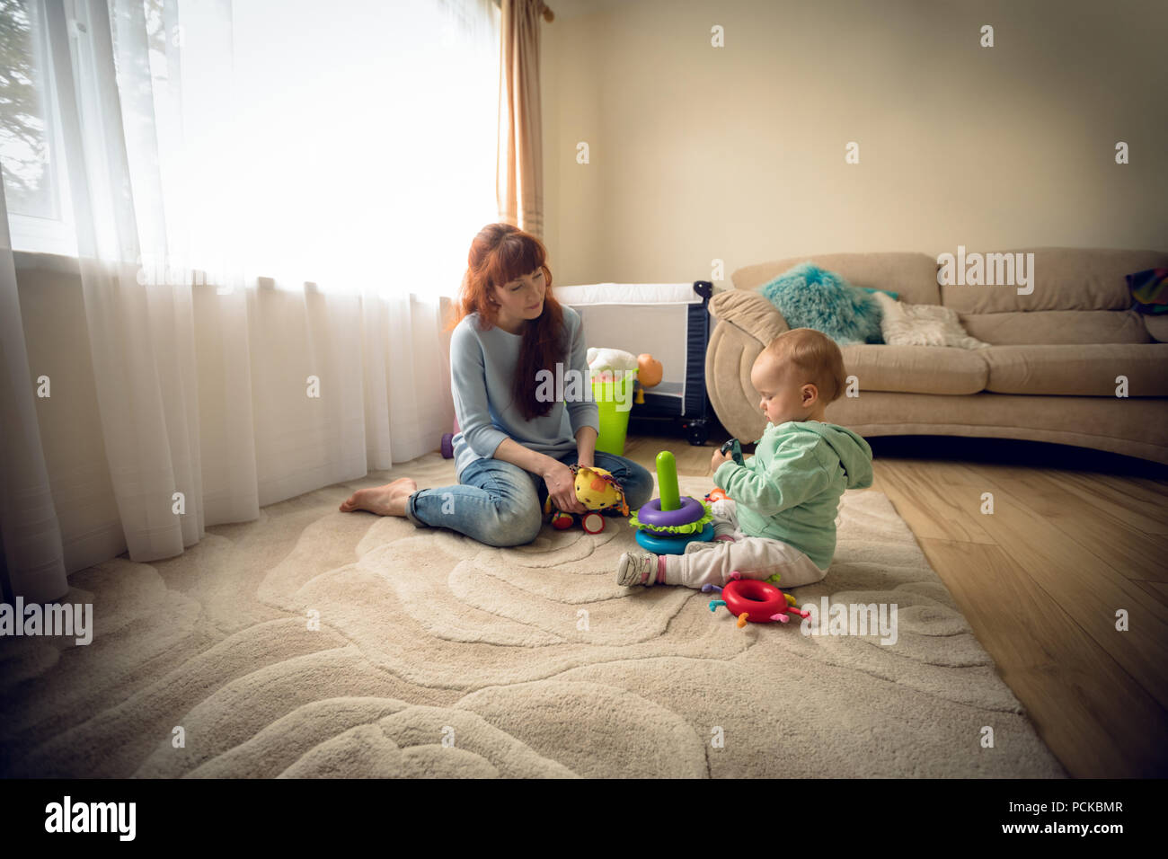 Mutter mit ihrem Baby Mädchen spielen mit Spielzeug Stockfoto