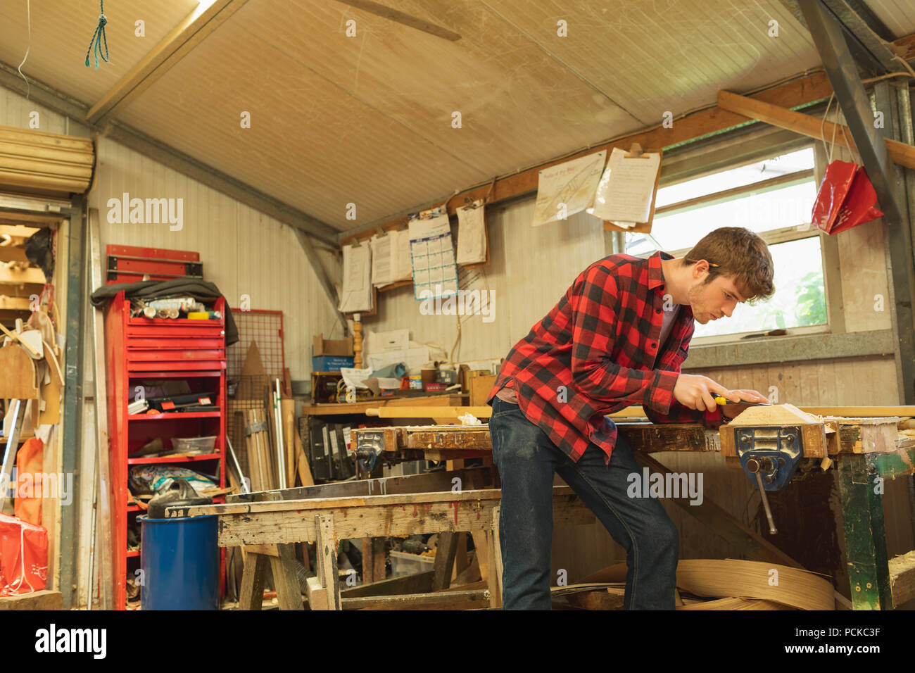 Männliche Tischler mit dem Flugzeug Werkzeug in der Werkstatt Stockfoto