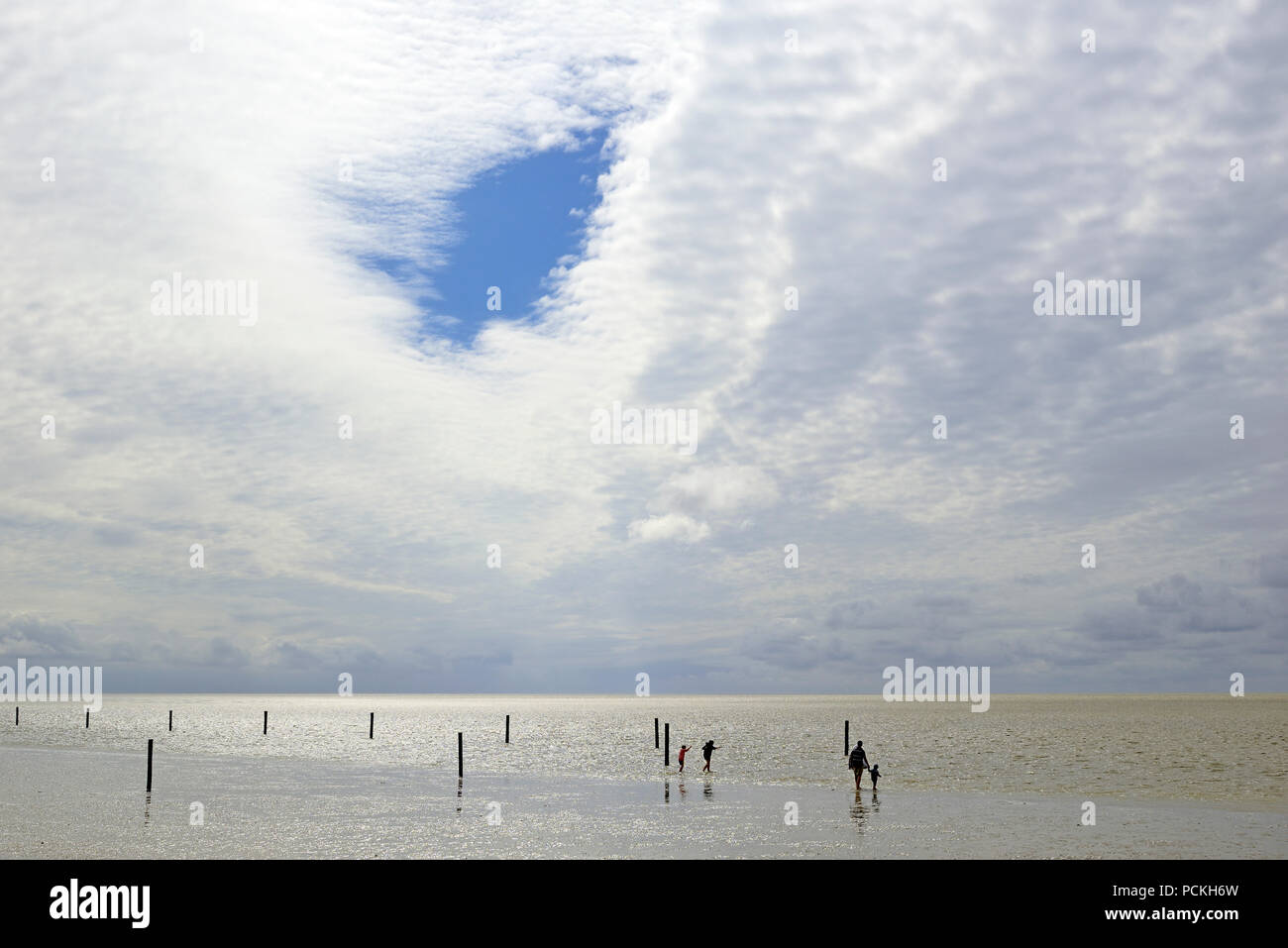 Personen in der Gezeitenzone an steigende Wasser, Norddeich, Nordsee, Niedersachsen, Deutschland Stockfoto