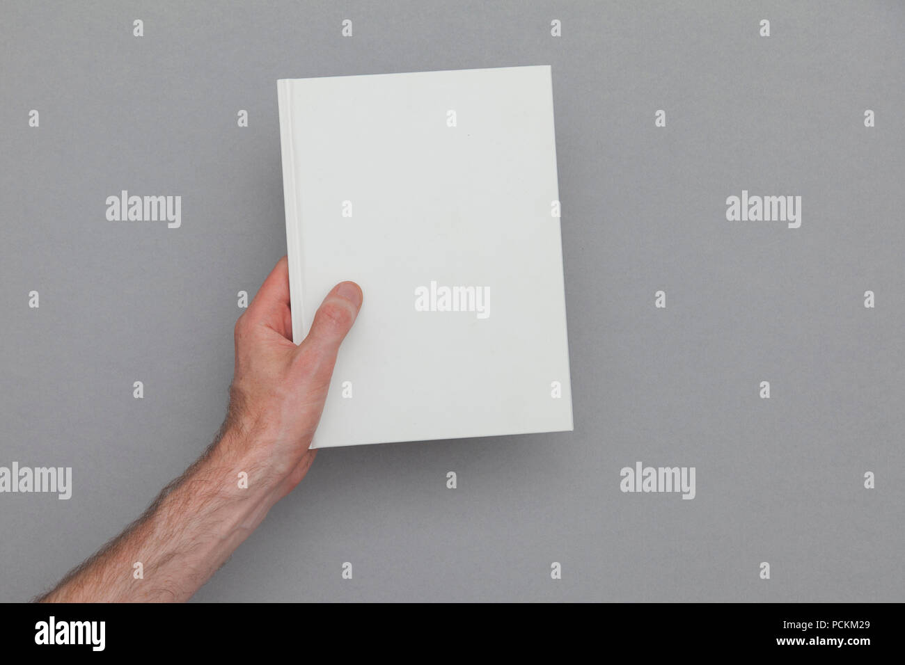 Männliche Hand ein geschlossenes Buch zeigt das Buch. Buchen Sie Mock up Vorlage. Stockfoto