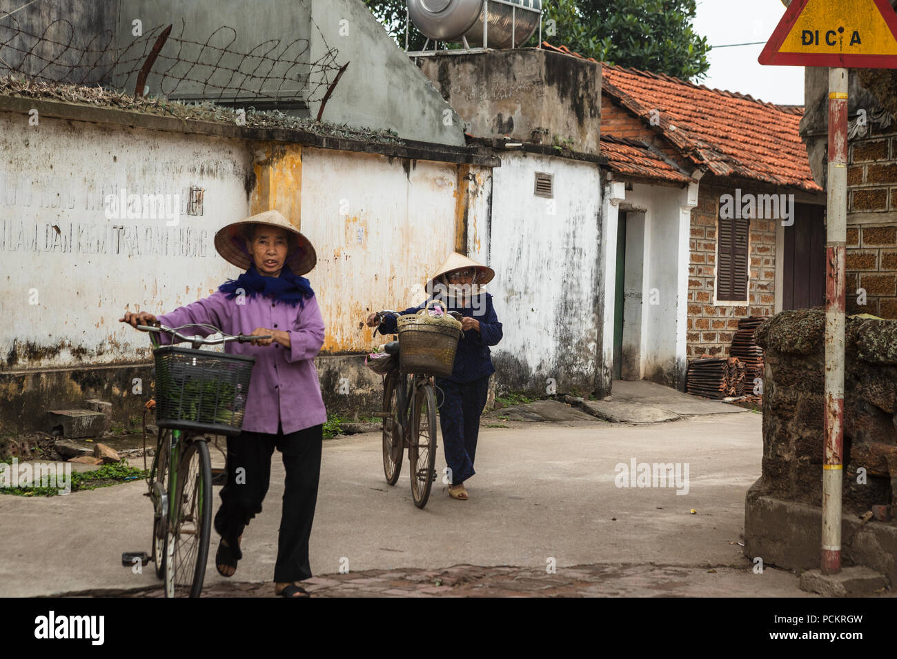 Duong Lam, Ha Noi, Vietnam-April 18, 2018: vietnamesische Frau mit dem Fahrrad zum Einkaufen in den ländlichen Gebieten von Ha Noi. Sie tragen, was sie kauften von tradit Stockfoto