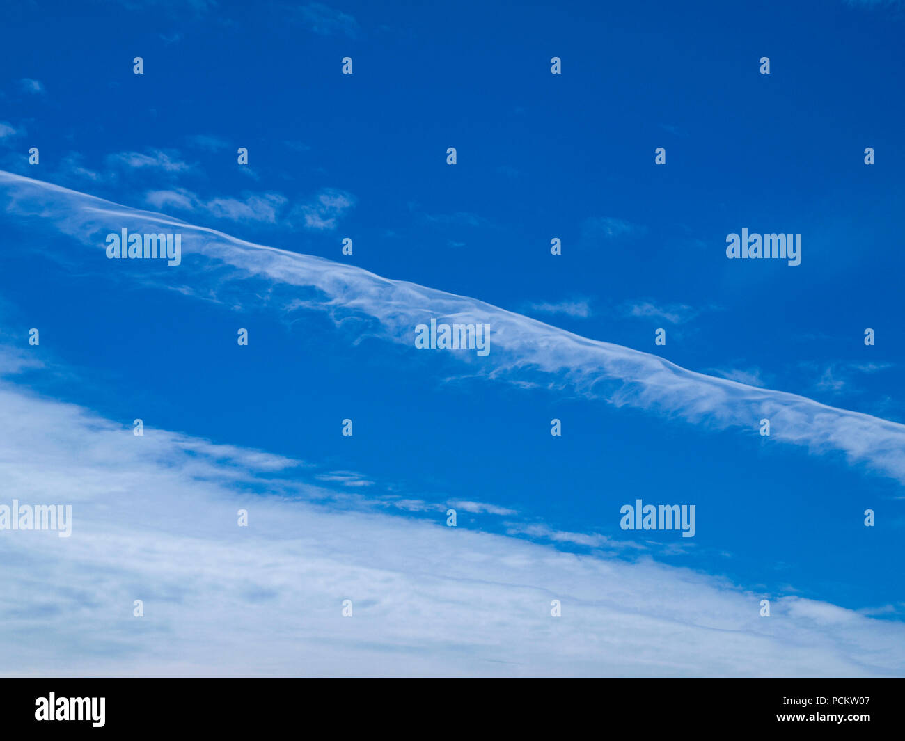 Eine bunte Kondensstreifen und Zirruswolken sky cloudscape mit einem Vapor Trail Wolkenbildung in der Mitte der blauen Himmel. New South Wales, Australien. Stockfoto
