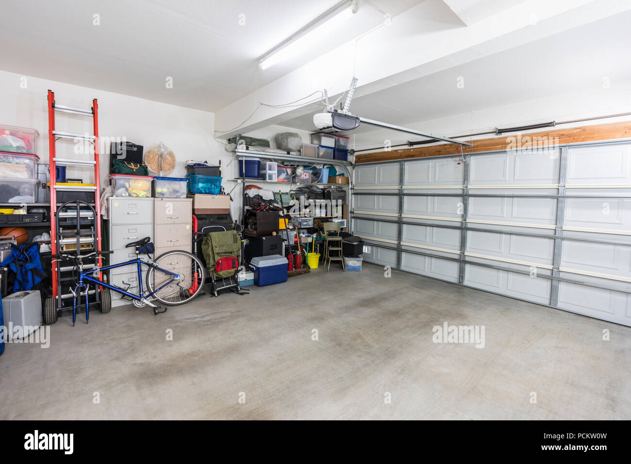 Organisierte suburbanen Wohn- garage mit Regalen, Aktenschränke, Werkzeuge und Sportgeräte. Stockfoto