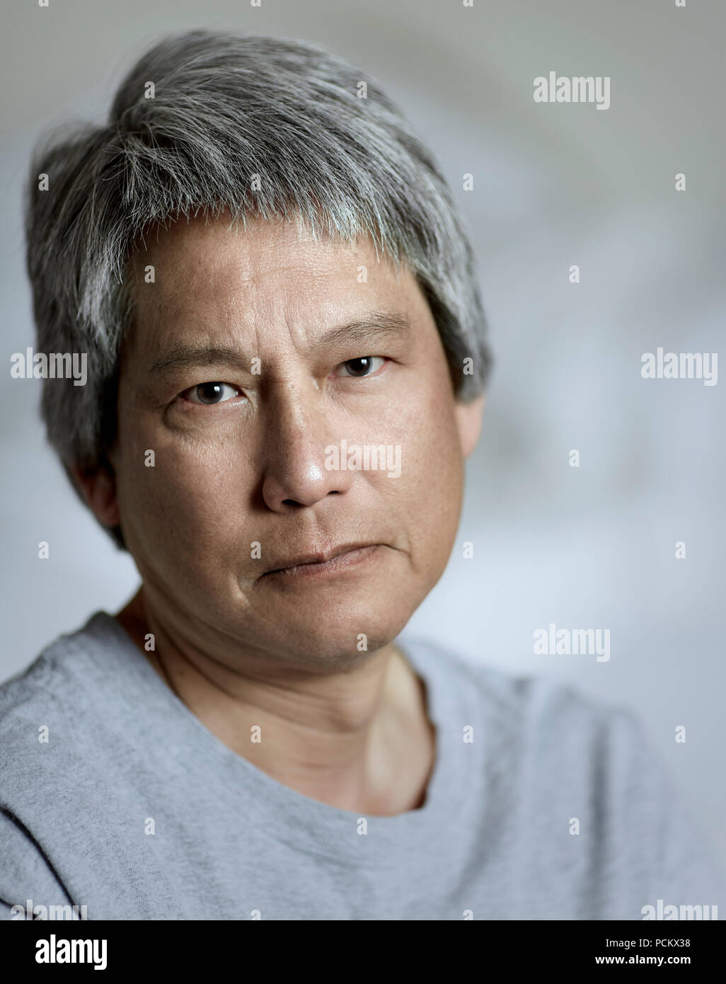 Porträt eines chinesischen Mann mit Grau, lächelnd mit geringer Tiefenschärfe Stockfoto