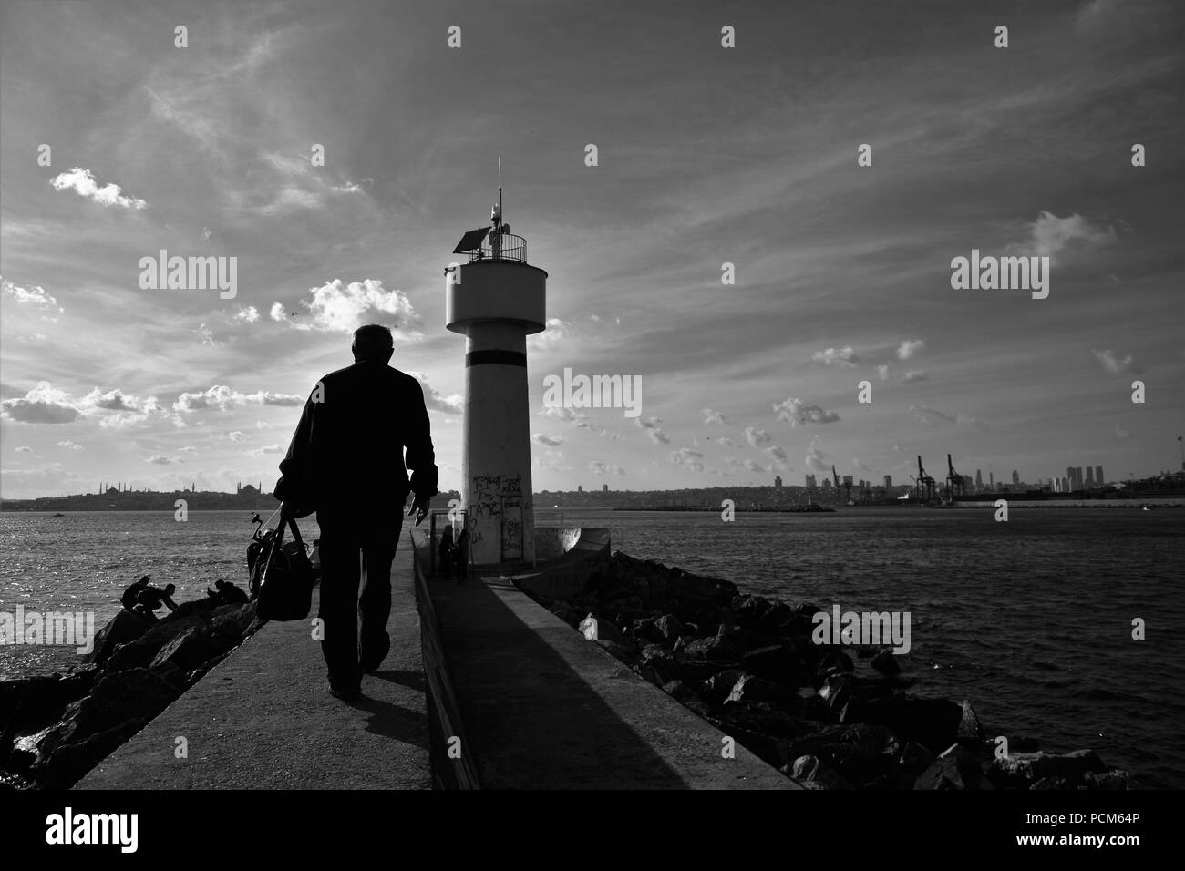 Leute um kadiköy Leuchtturm hängen an einem sonnigen Tag und das Stadtbild im Hintergrund Stockfoto