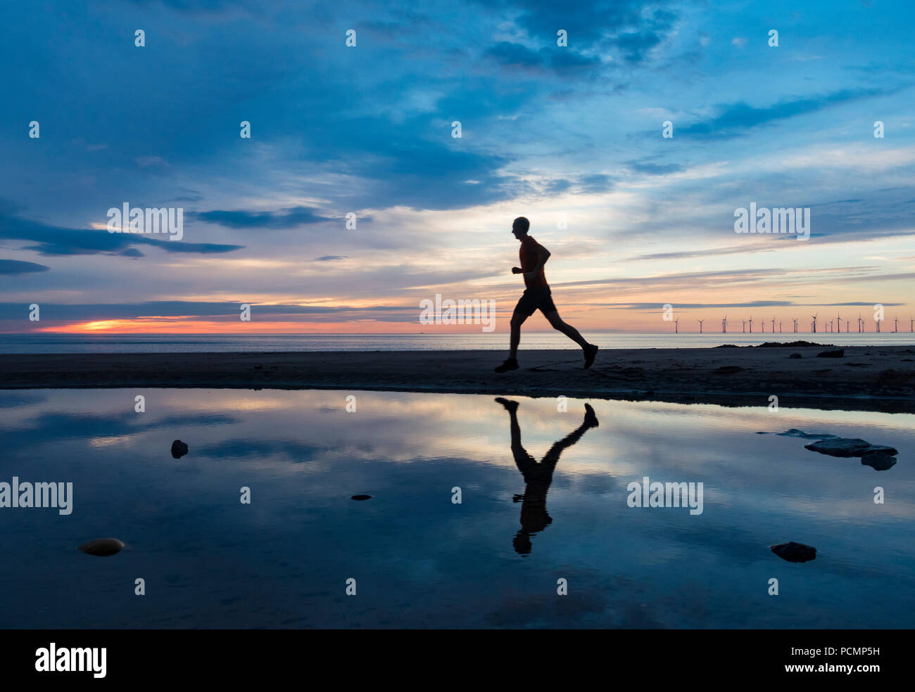 Seaton Carew, County Durham, England. Vereinigtes Königreich. 3. August 2018. Wetter: einen lauen Start bis Freitag an der nordöstlichen Küste als Jogger Fortschritte auf Seaton Carew Strand bei Sonnenaufgang. Credit: ALAN DAWSON/Alamy leben Nachrichten Stockfoto