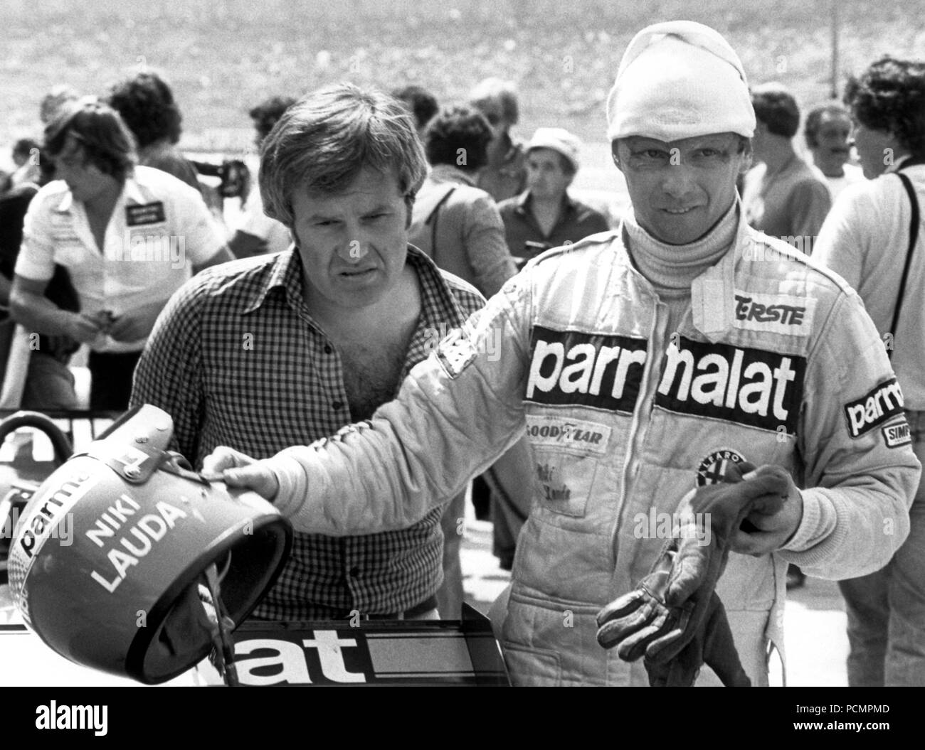Österreichischen Formel-1-Pilot Niki Lauda zieht Helm und Handschuhe bei einem Boxenstopp im Training zum Grand Prix von Deutschland auf dem Hockenheimring am 27. Juli 1979. Der Mann zu seiner Linken ist nicht identifiziert. | Verwendung weltweit Stockfoto