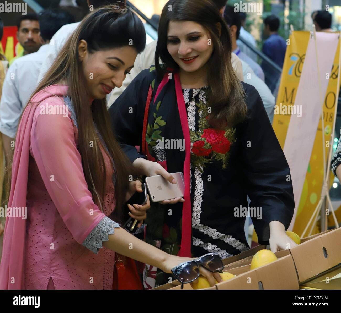 Islamabad. 3 Aug, 2018. Frauen besuchen Sie eine Mango während mango Festival in Islamabad, der Hauptstadt Pakistans am 3. August 2018. Eine dreitägige mango Festival begann in Islamabad am Freitag, Anzeigen über zehn verschiedene Rassen von hoher Qualität Mangos. Credit: Ahmad Kamal/Xinhua/Alamy leben Nachrichten Stockfoto