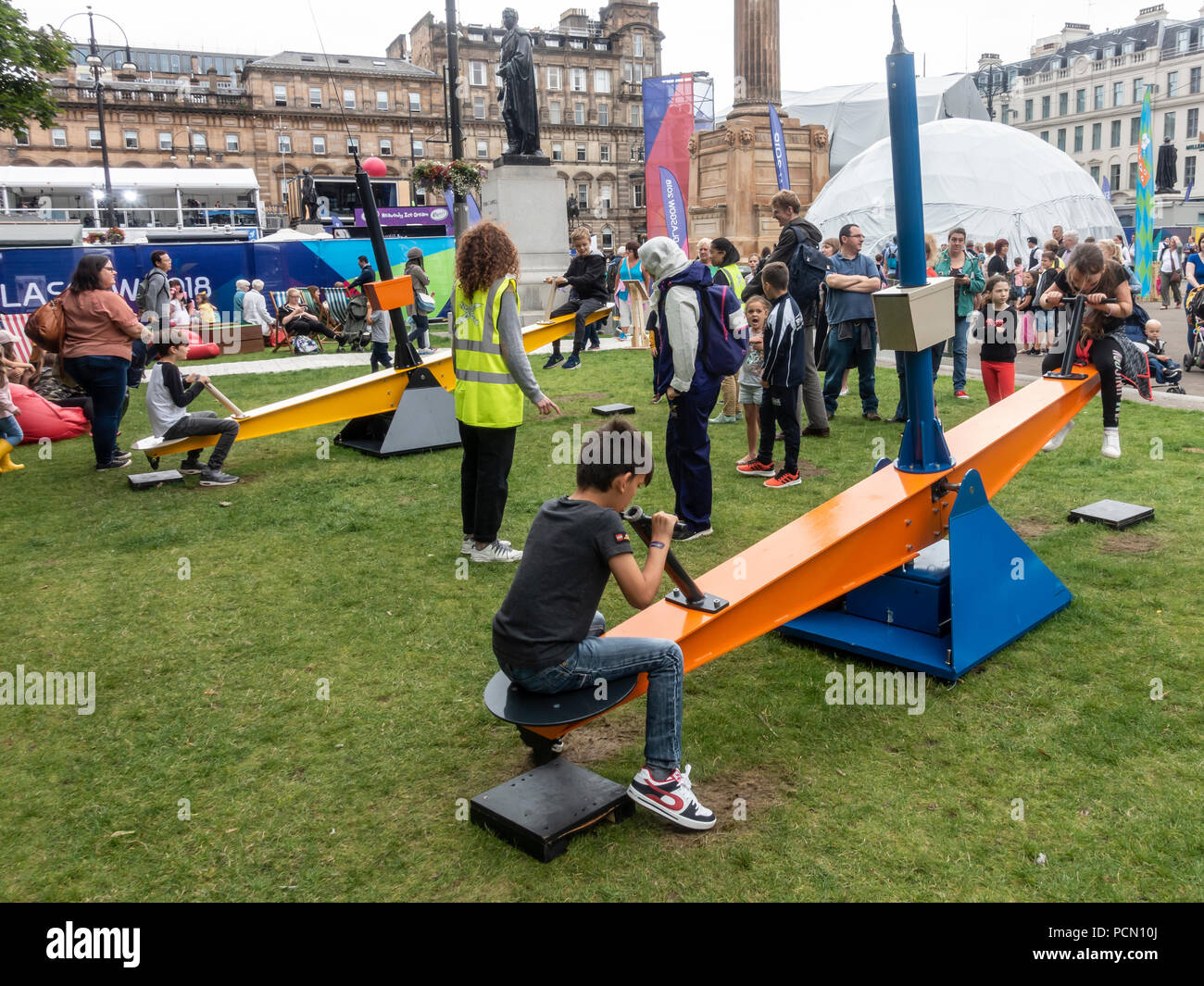 Kinder spielen auf einer interaktiven Installation genannt, Drehen, Schaukeln mit AI mit Benutzern zu chatten, auf dem George Square im Zentrum von Glasgow, wo sich die Menschen entspannen und genießen Festival 2018. Das Festival läuft parallel mit der Europäischen Meisterschaften; Glasgow 2018. George Square ist ein frei Ort mit mehreren Leben und virtuellen Attraktionen täglich. Credit: Elizabeth Leyden/Alamy leben Nachrichten Stockfoto