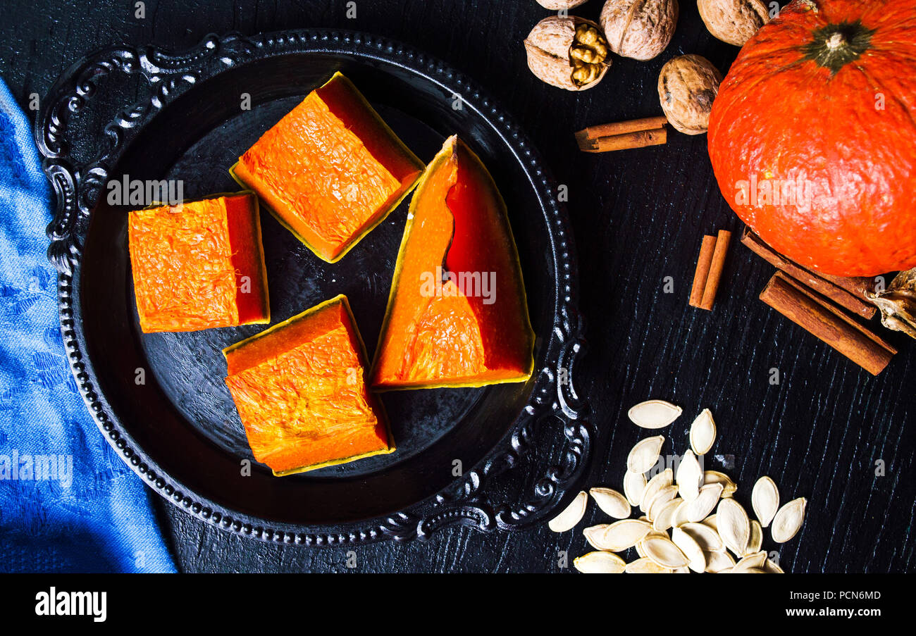 Gebratene Kürbisscheiben auf einem dunklen Platte, gesunden Snack Stockfoto