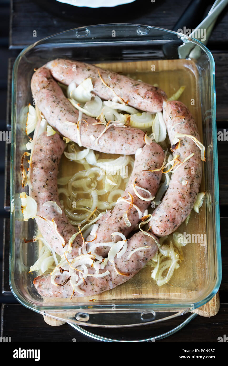 Weißwurst gebacken mit Zwiebeln in Auflaufform Stockfoto