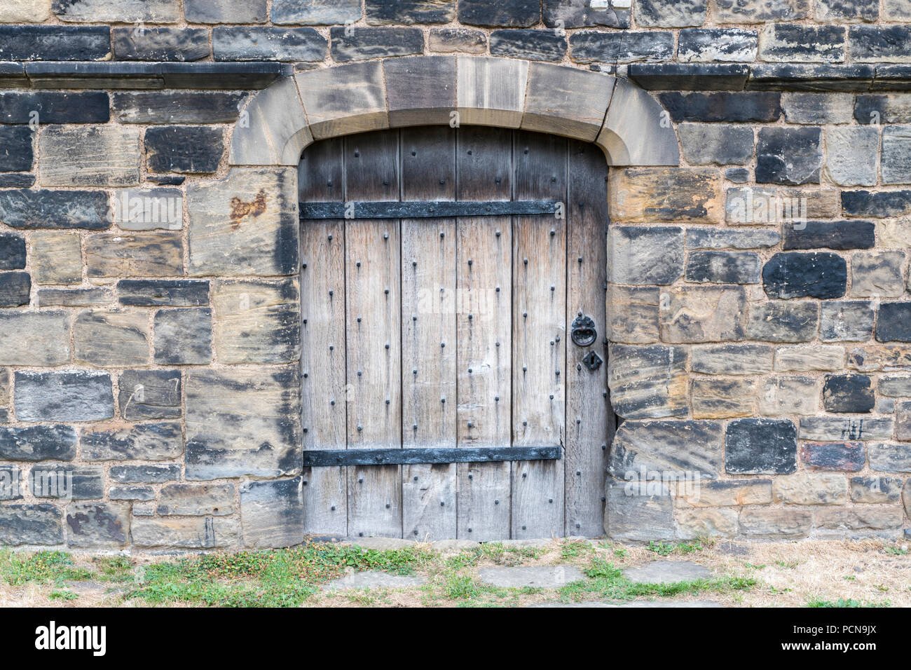 Alte Tür mit schmiedeeisernen Befestigungen Stockfoto