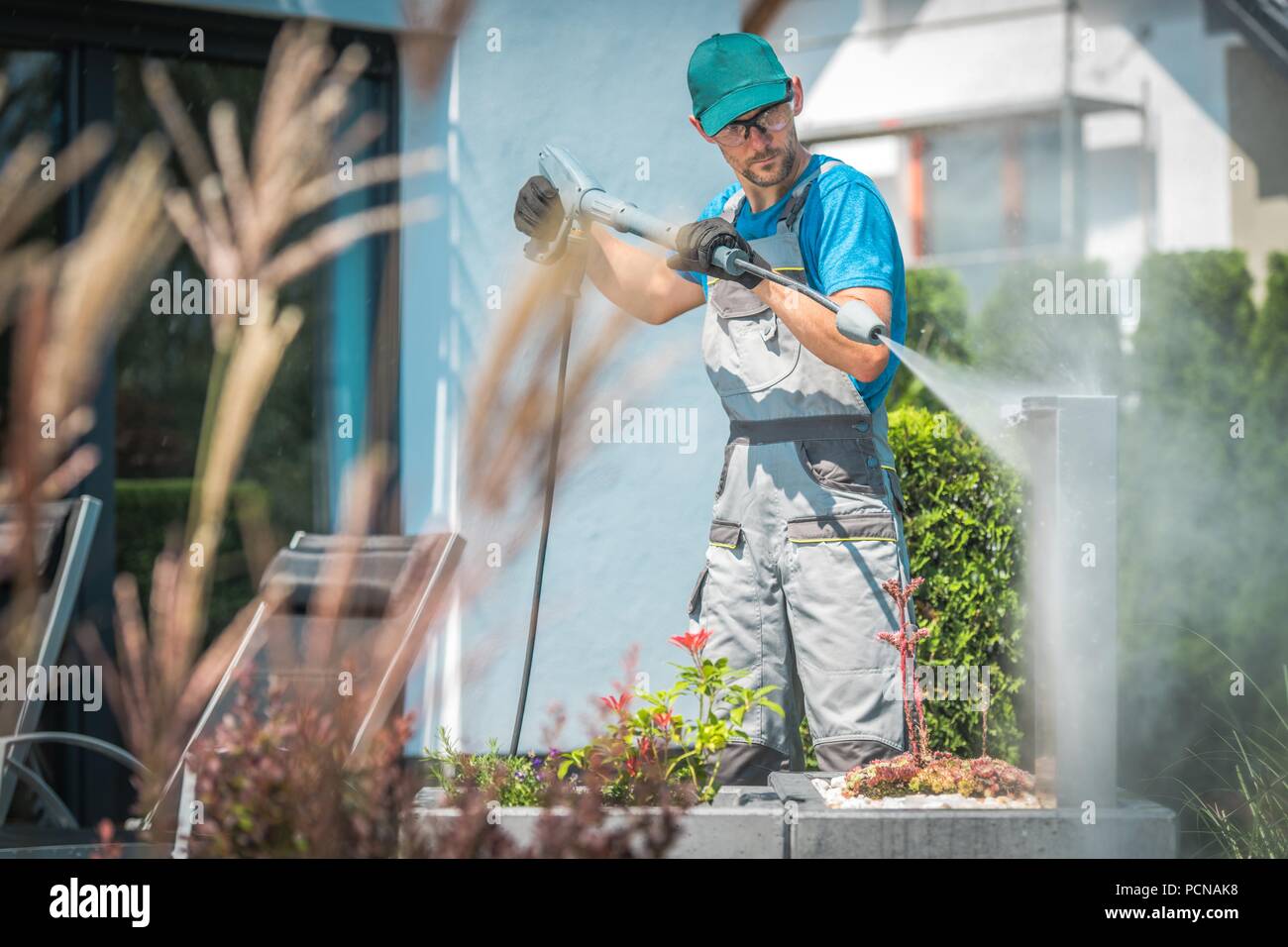 Druck Waschen im Garten. Kaukasischen Männern in seinem 30s und der Frühjahrsputz. Stockfoto