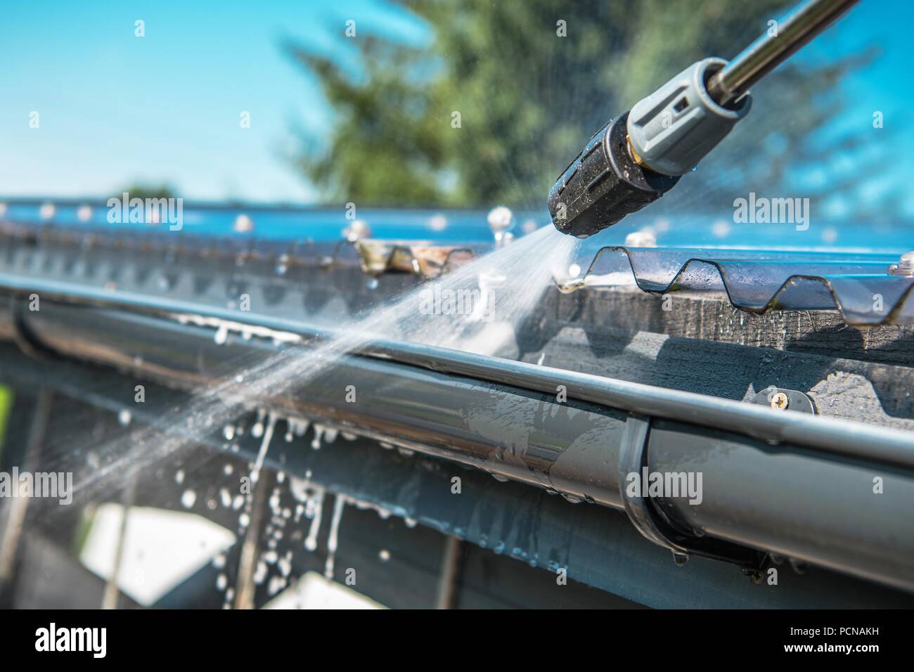 Feder Regenrinnen Reinigung mit Hochdruckreiniger. Closeup Foto. Stockfoto