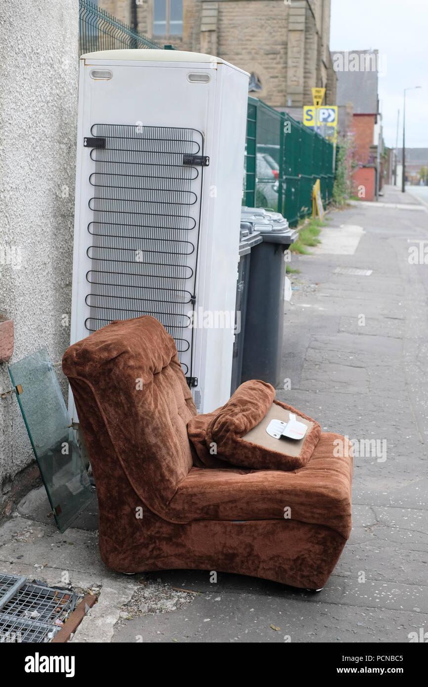 Hausmüll einschließlich einen Stuhl und frisge Gefrierschrank in der Straße links Stockfoto