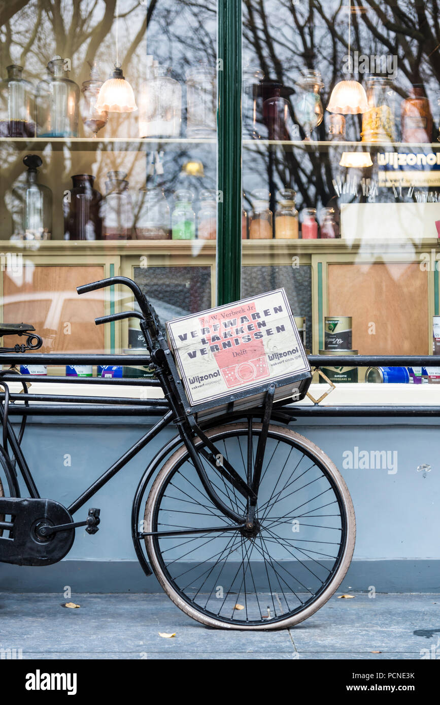 Old Dutch's und beg'Fahrrad gegen ein Hardware shop Fenster in Delft, Niederlande schiefen Stockfoto