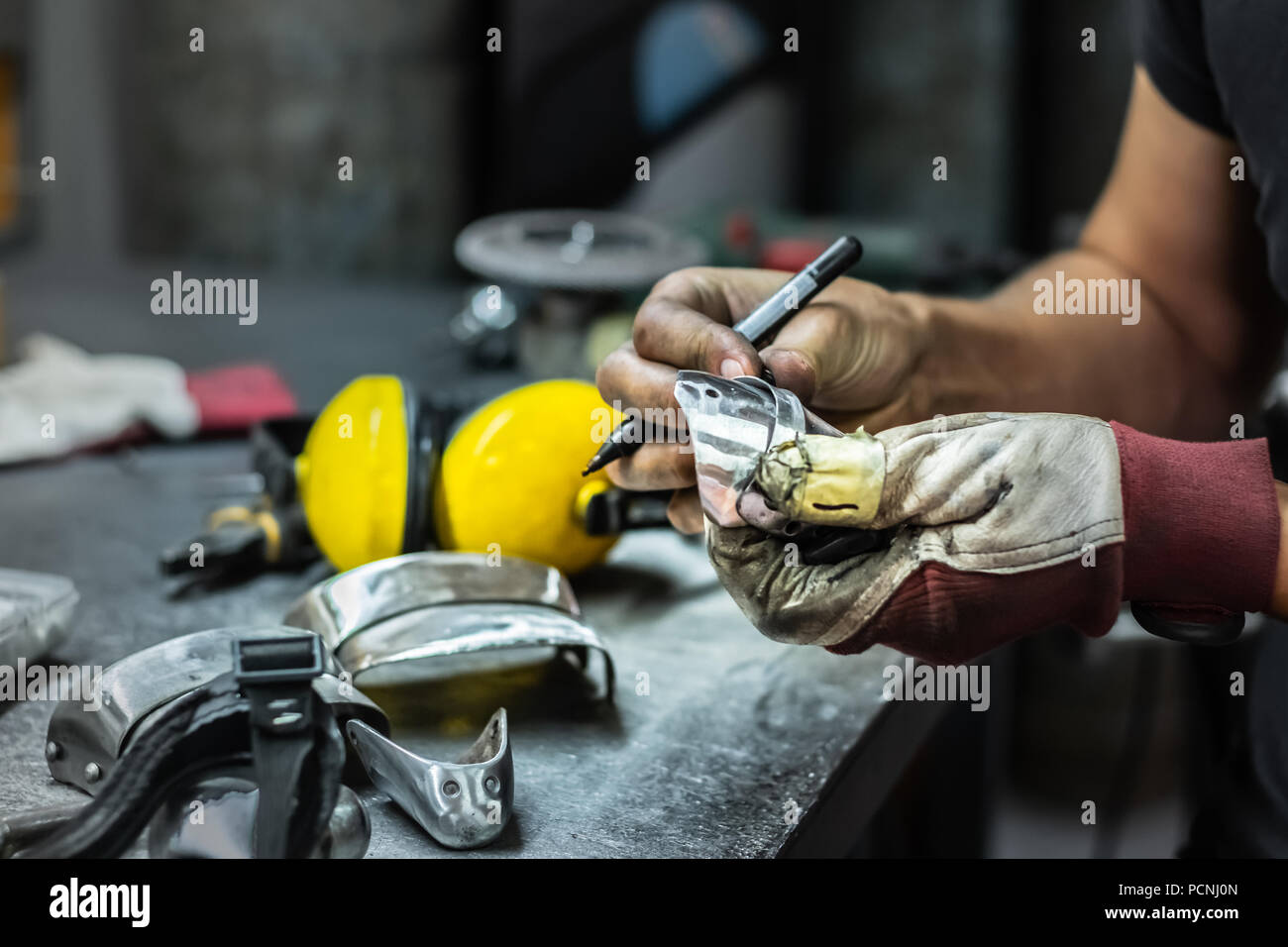 Männliche Metallarbeiter, Bau und Montage Stück der mittelalterlichen Rüstung. Mann die Hände arbeiten mit Metall Teile der Hardware in einem Workshop Stockfoto