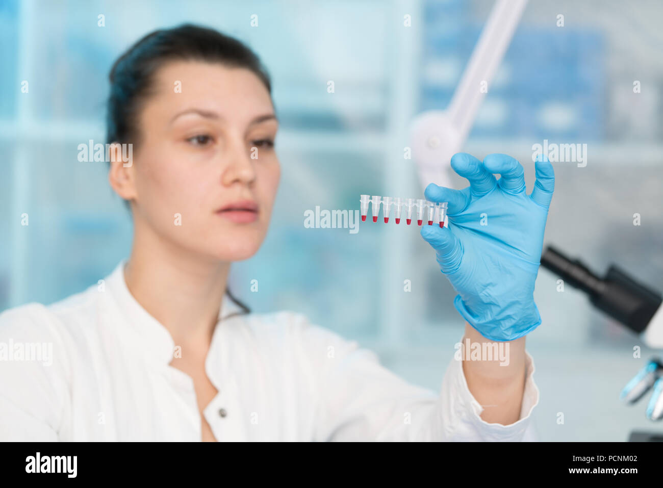 Junge Frau mit der genetischen Forschung im Labor Forschung von Krebserkrankungen Stockfoto