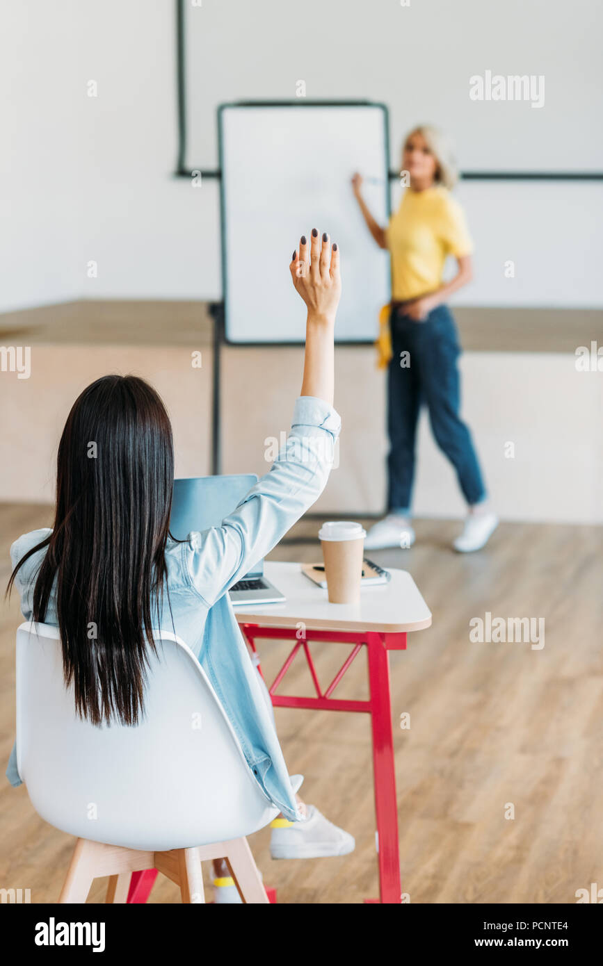 Ansicht der Rückseite des Student Hand in der Frage des Lehrers zu beantworten Stockfoto