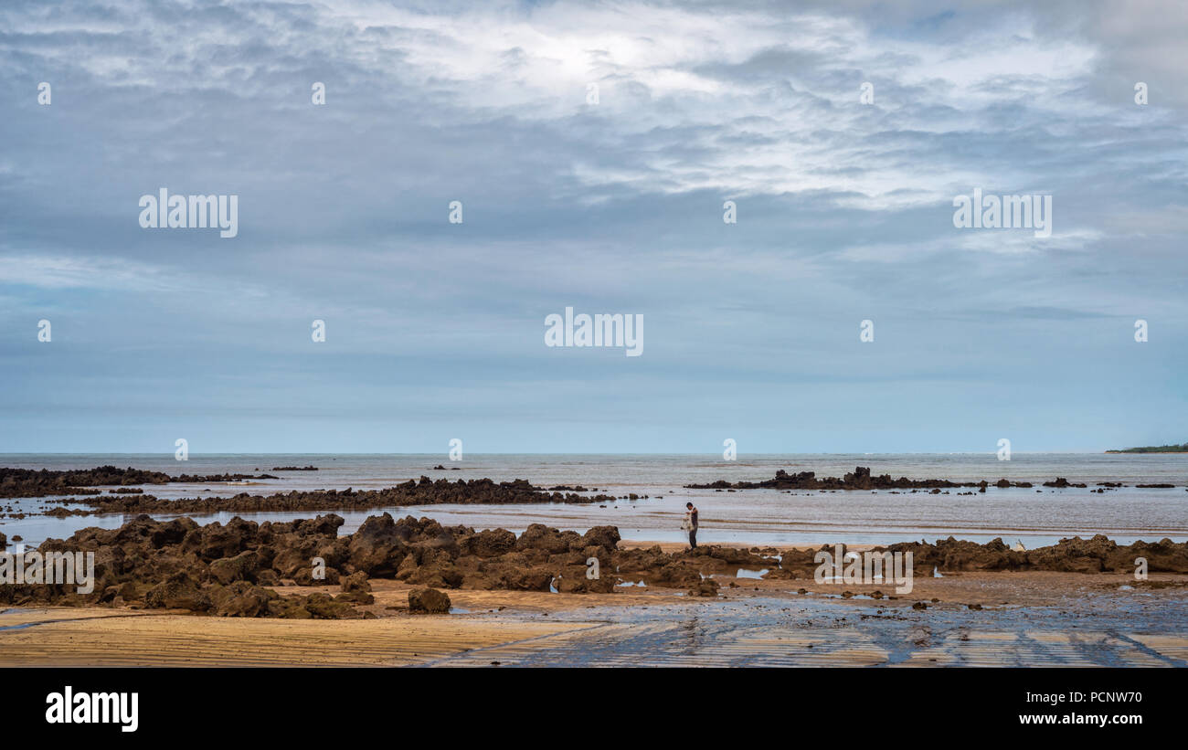 FUNDAO, Espirito Santo, Brasilien - 30. Juni 2018: ein einsamer Fischer wirft seine Fischernetz in Strand Praia Grande. Stockfoto