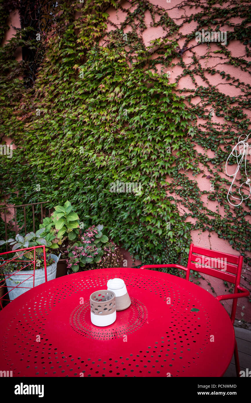 Rote metall Tisch auf der Terrasse von einem Garten im mediterranen Stil Haus in der Provinz Gerona in Katalonien Spanien Stockfoto