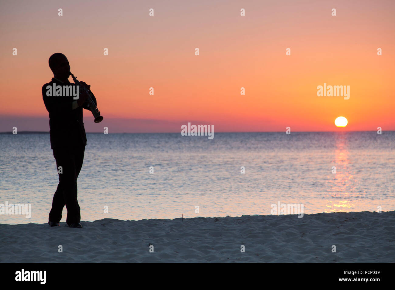 Karibik, Kuba, Cayo Santa Maria, Saxophonist, Sonnenuntergang und das Meer im Hintergrund Stockfoto