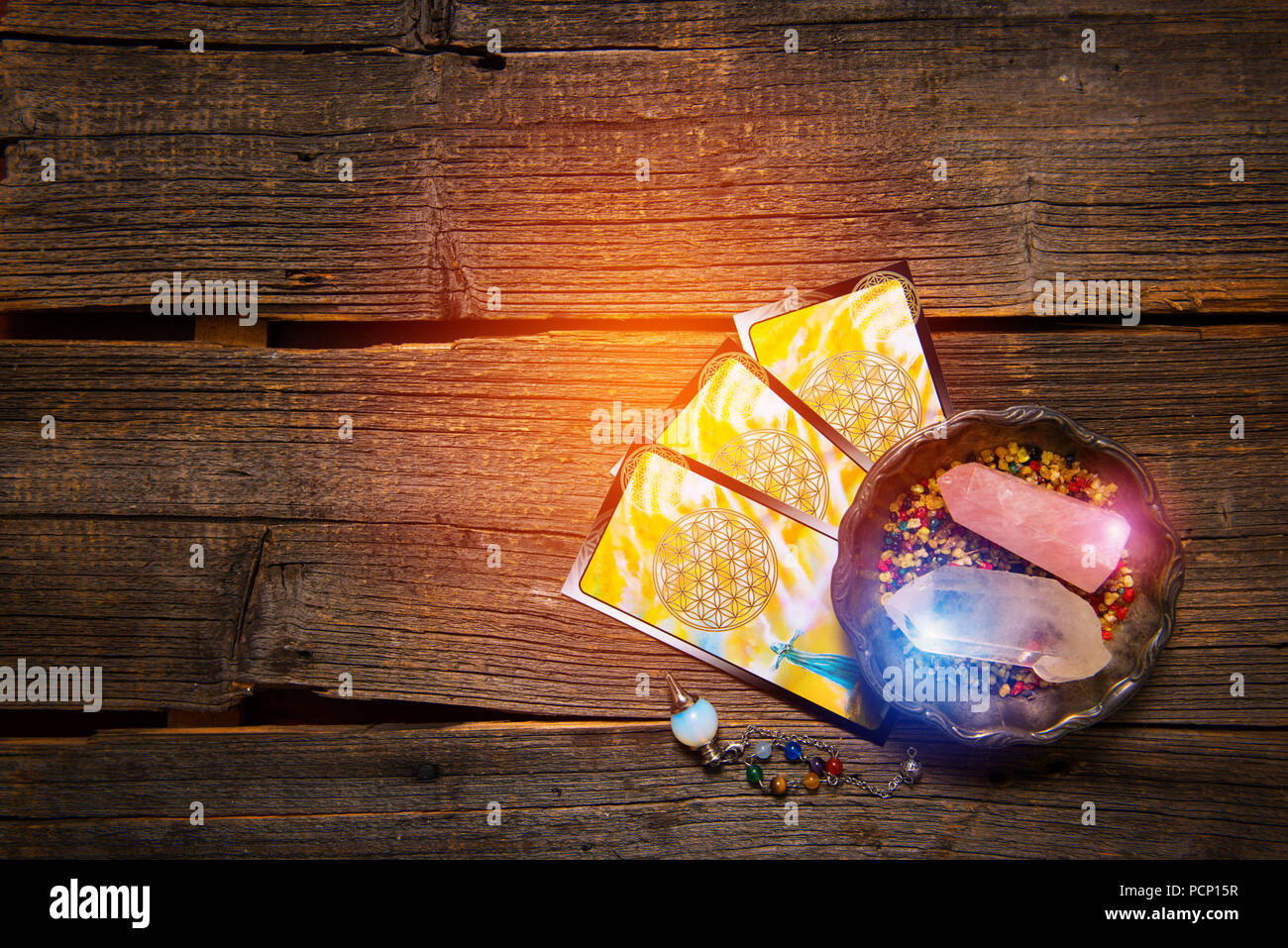 Tarot Karten, Pendelwerkzeug und Kristalle auf einem Holzbrett mit Platz für Ihren Text kopieren Stockfoto