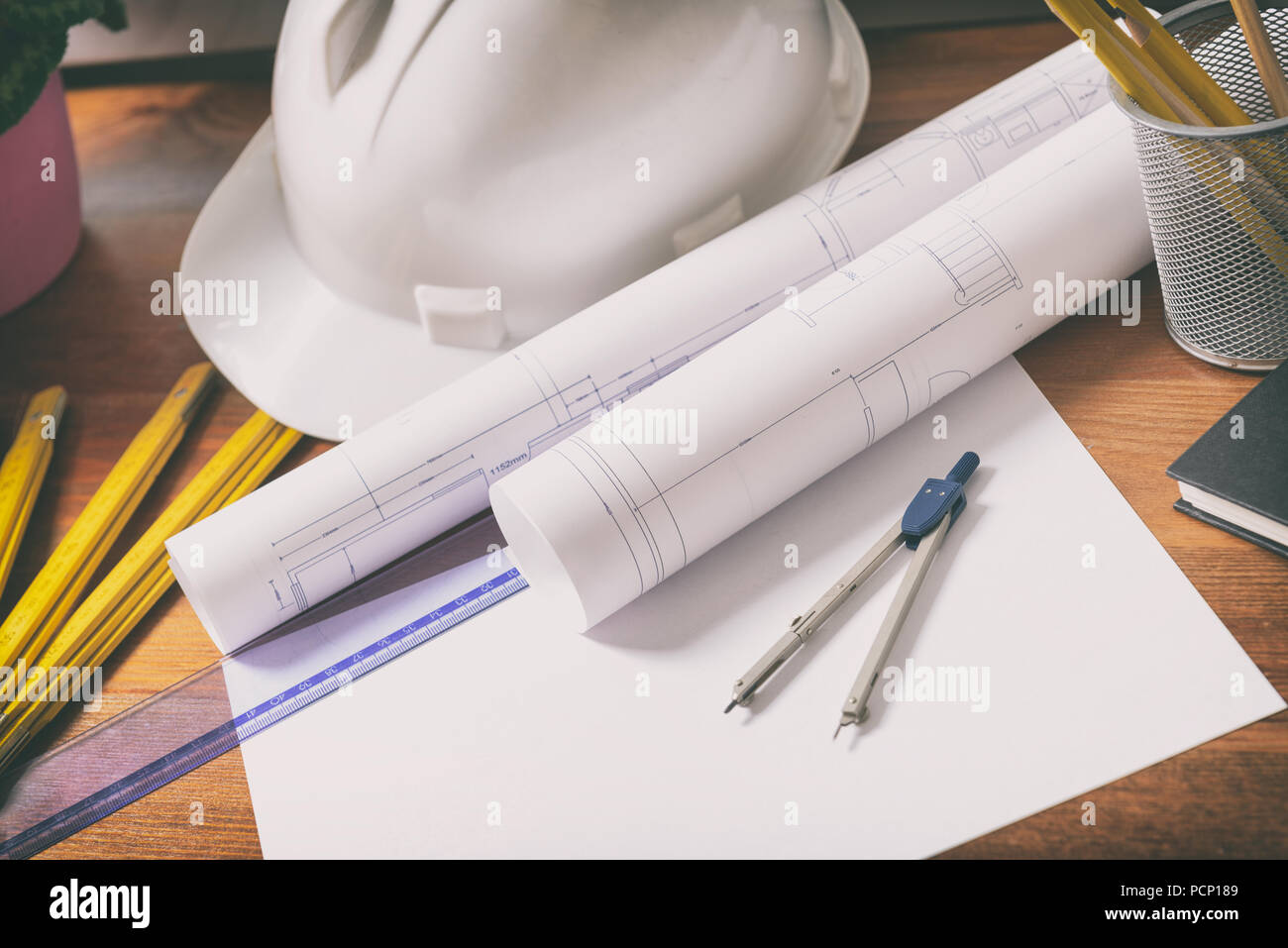 Baupläne mit Helm und Werkzeugen auf Blueprints und Messen Stockfoto