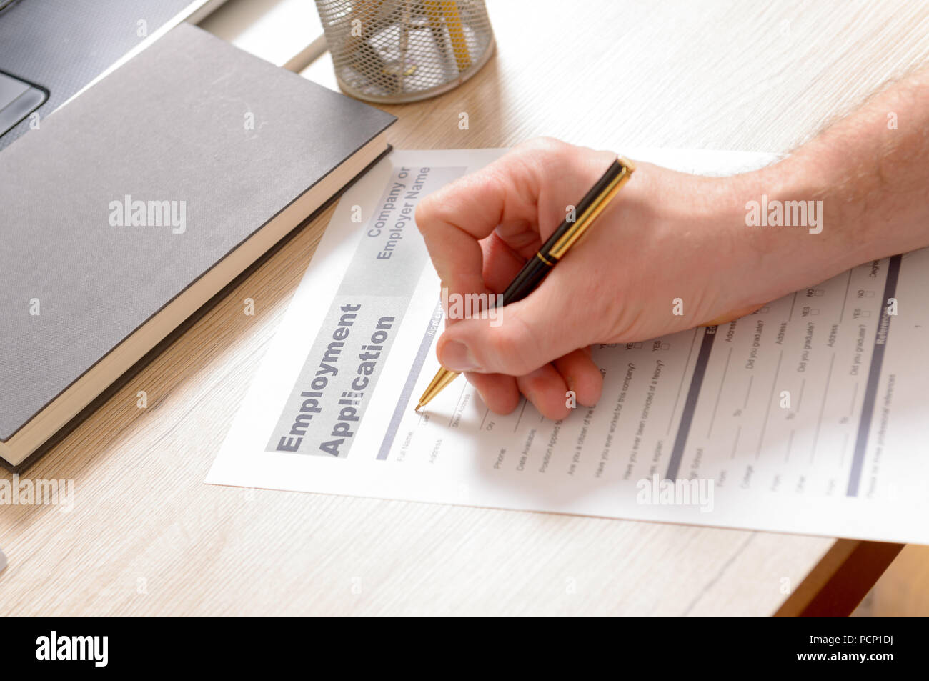 Abfüllung in Leer Bewerbung form in den Händen auf einem Schreibtisch Stockfoto