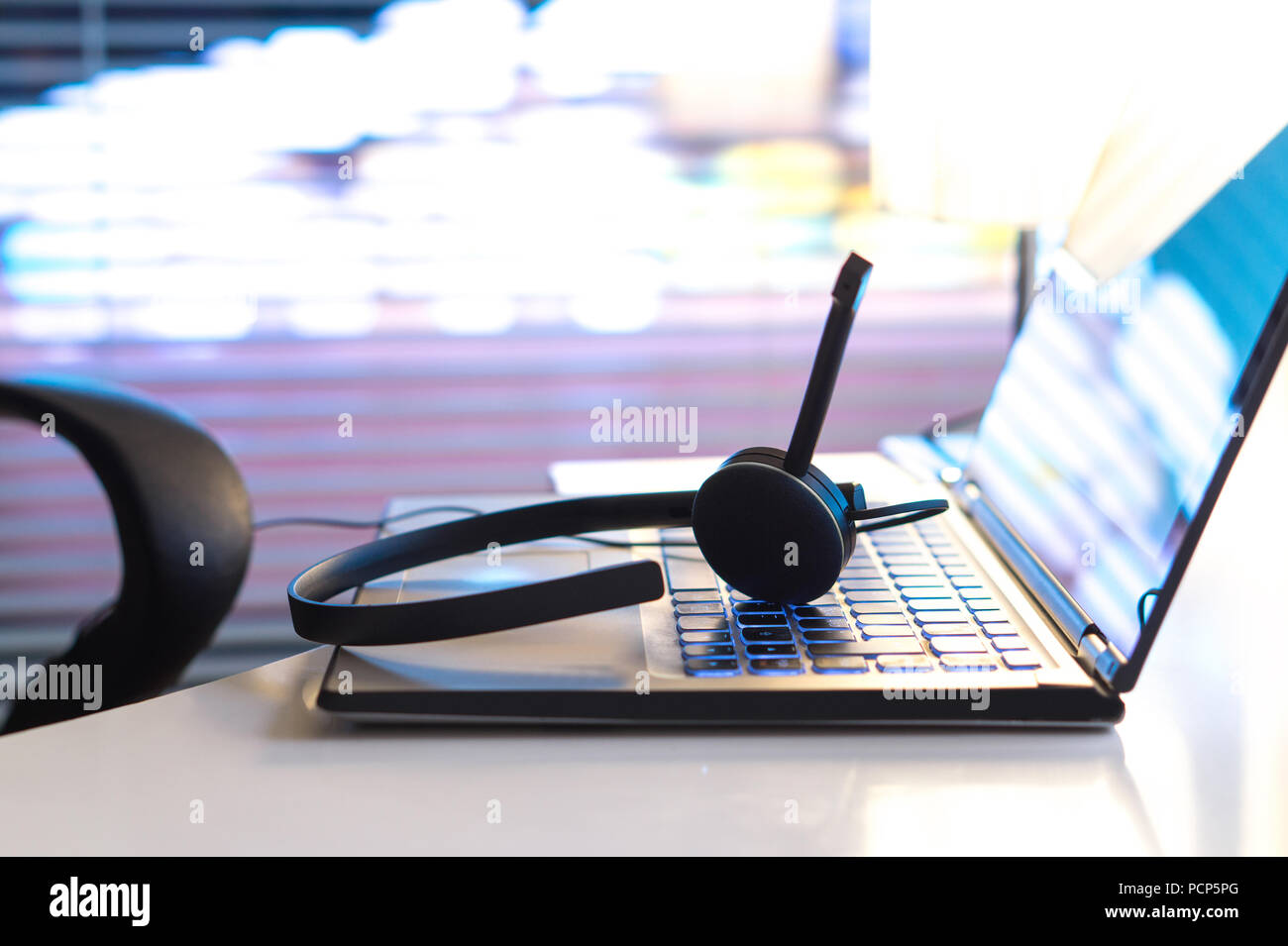 Help Desk, rund um die Uhr Kundendienst, Support Hotline oder Call Center Konzept. Auf Laptop Tastatur Headset spät in der Nacht im Büro. Video Konferenz. Stockfoto