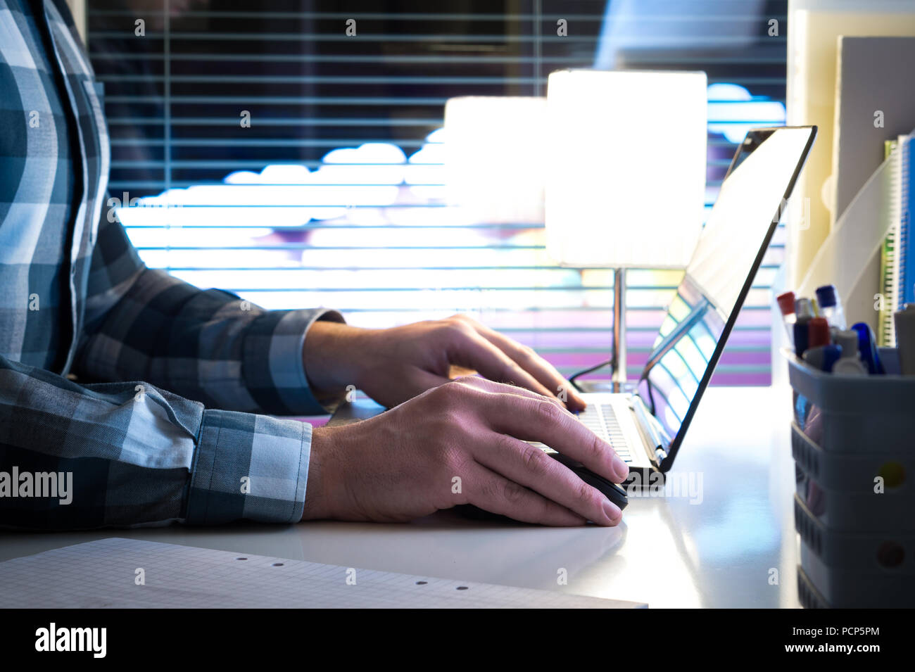 Spät in der Nacht, Überstunden oder Überarbeitung Konzept. Mann mit Laptop in der modernen Business Office mit unscharfen Stadt Hintergrund. Stockfoto