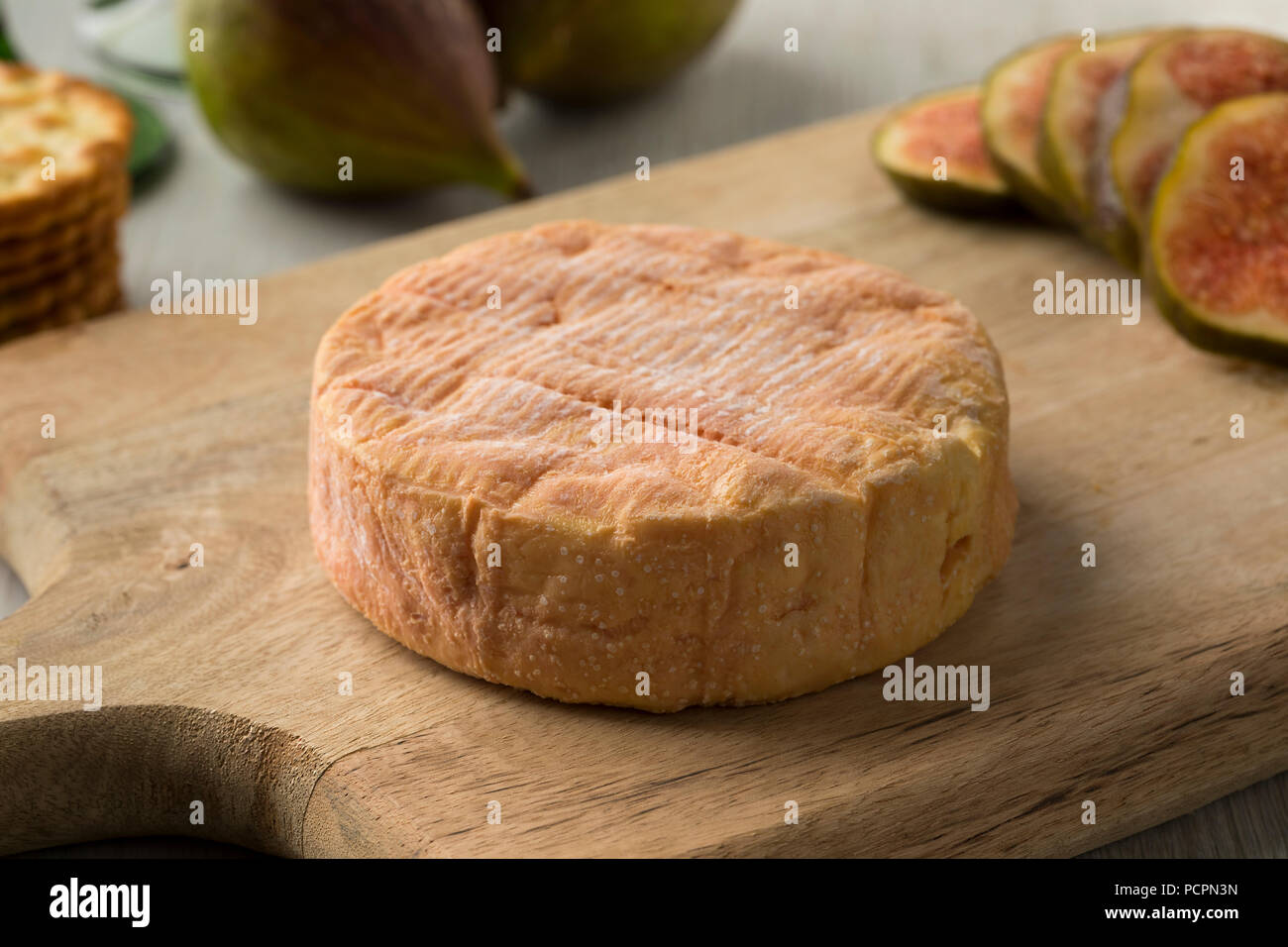 Ganze reife petit Munster Käse und frische Feigen auf dem Hintergrund zum Nachtisch Stockfoto