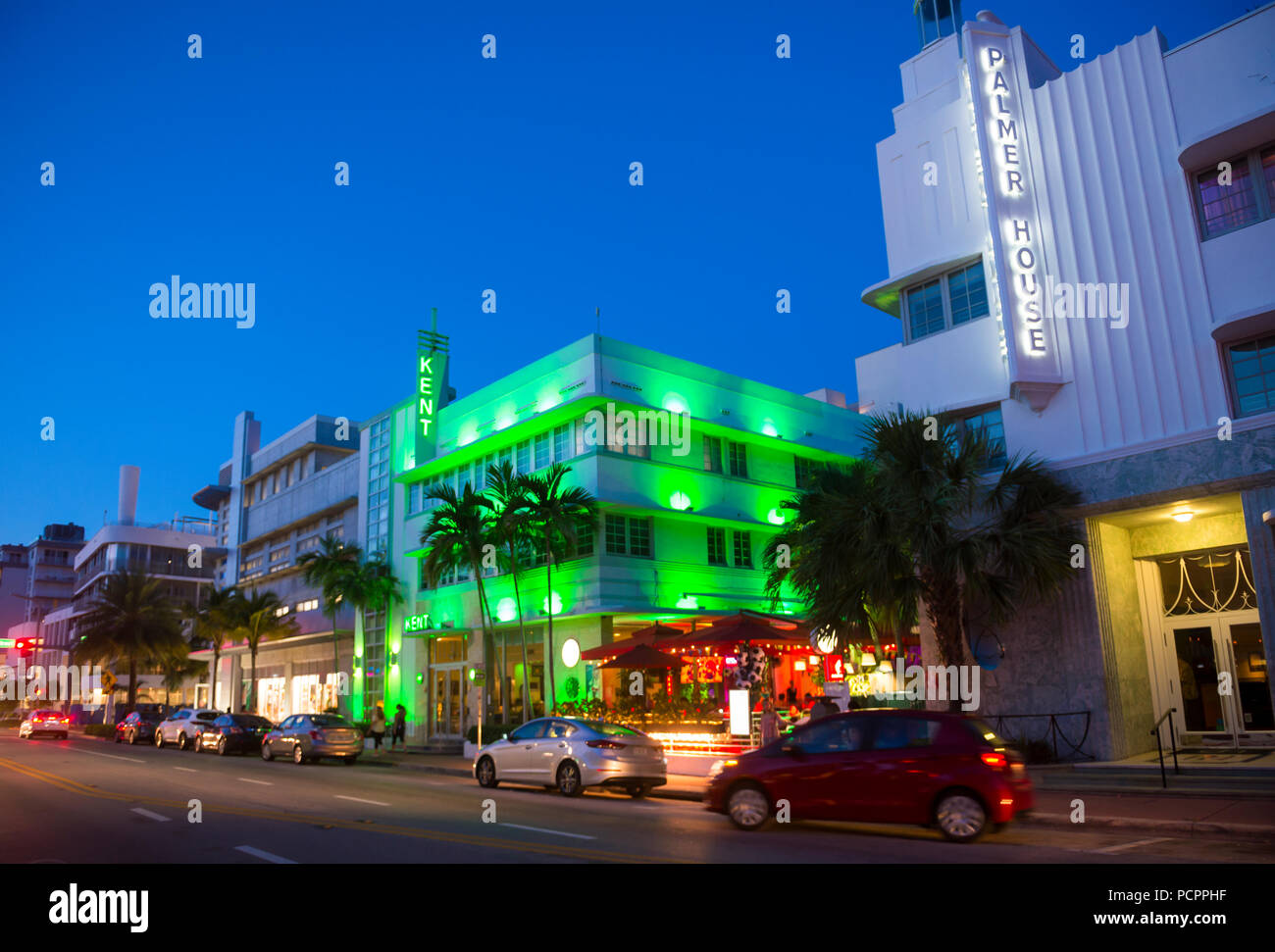 MIAMI - ca. Januar 2018: Autos fahren vorbei an berühmten Art déco-Hotels und Leuchtreklamen an der Collins Avenue in South Beach bei Nacht. Stockfoto