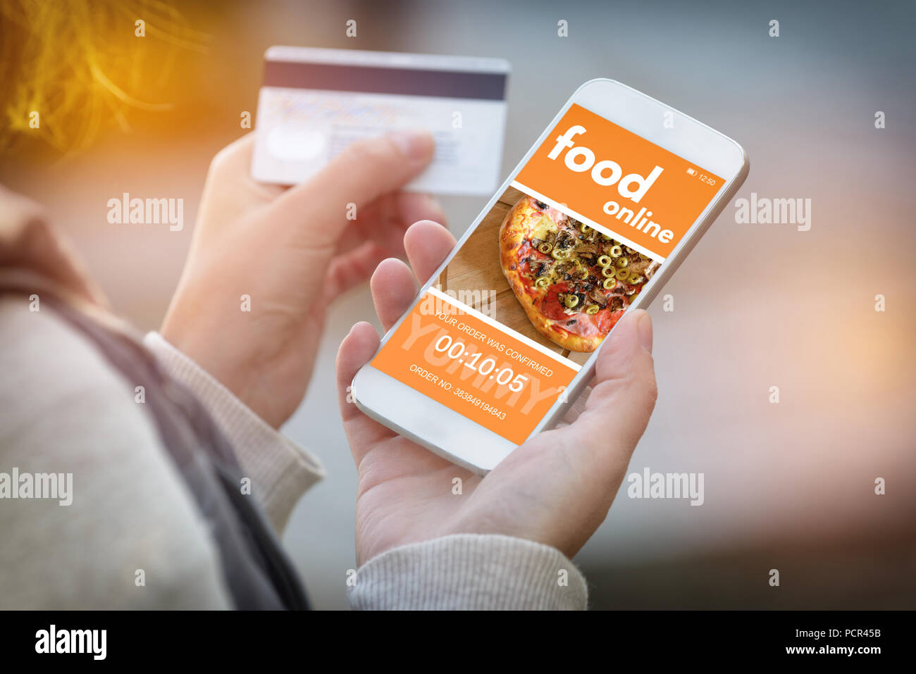 Essen bestellen online. Smartphone in der Hand und Kreditkarte in anderen. Konzept der Essen bestellen im Büro oder Arbeitsplatz. Stockfoto