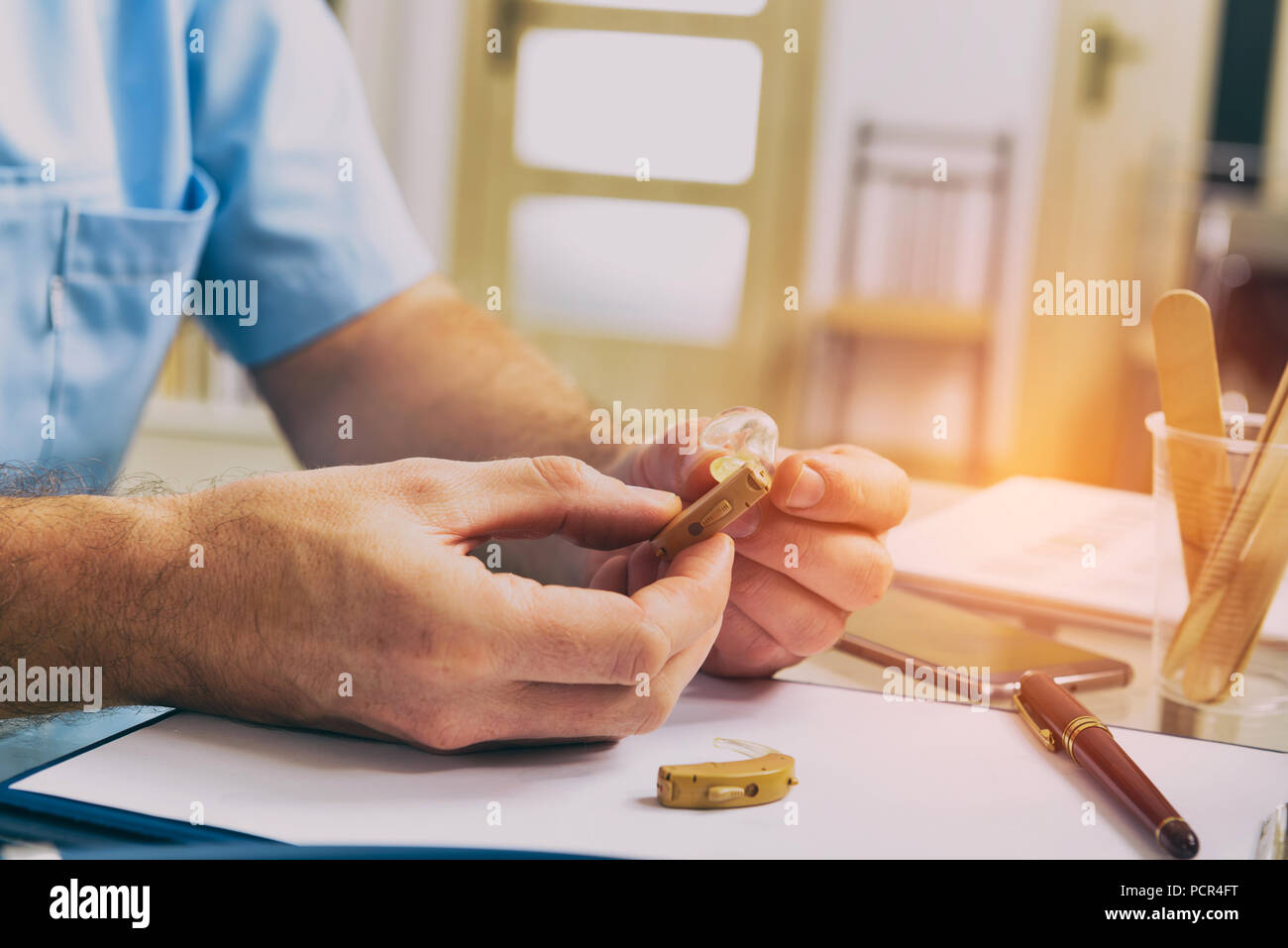 Arzt Audiologen holding Hörgerät in seiner Hand. Stockfoto