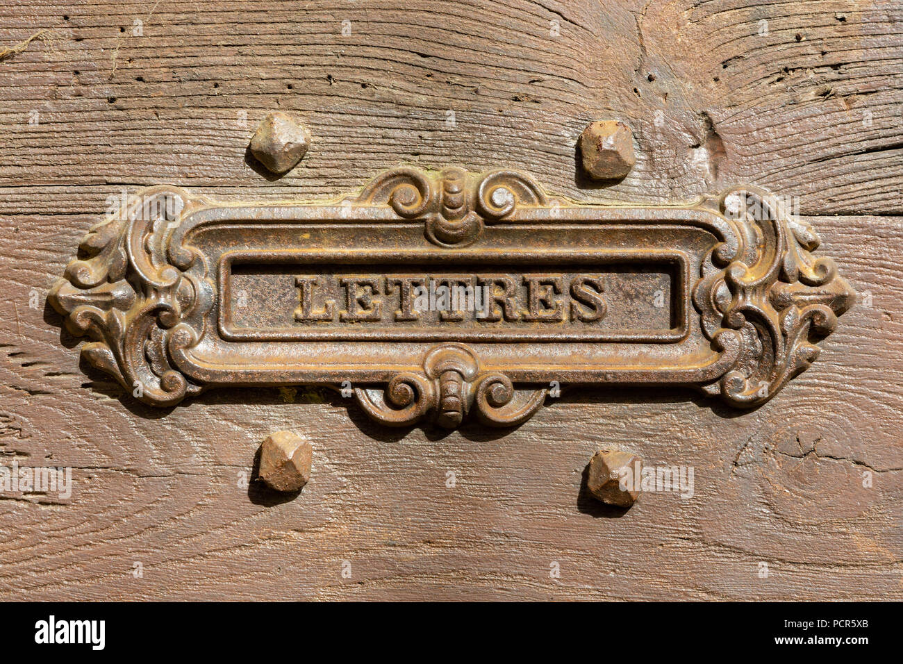 Frankreich, UZERCHE - Juli 12, 2018: Detail eines alten französischen Bügeleisen mail oder Brief Kasten in einem hölzernen Tür. Stockfoto