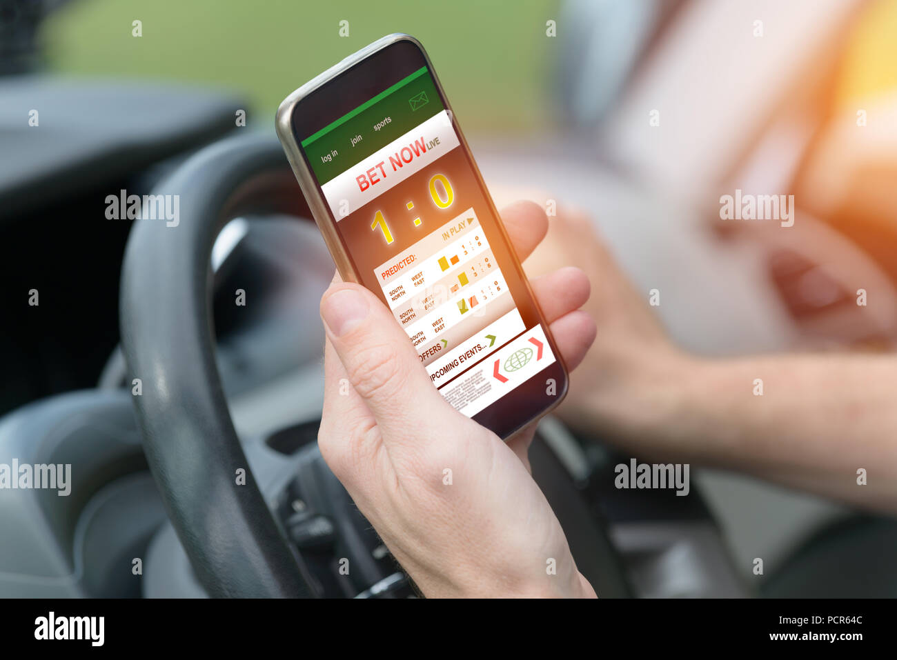 Wetten auf Sport, smart phone mit online Wetten mobile Anwendung während der Fahrt ein Auto Stockfoto