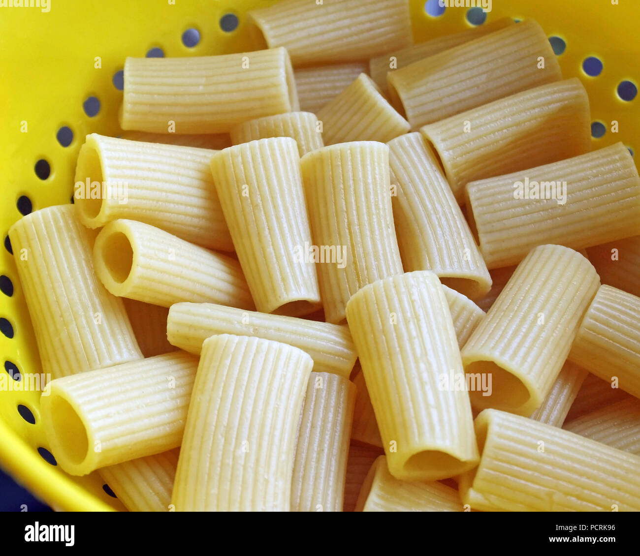 Abgelassen und gekochten Rigatoni Nudeln in einem gelben Kunststoff Sieb Stockfoto