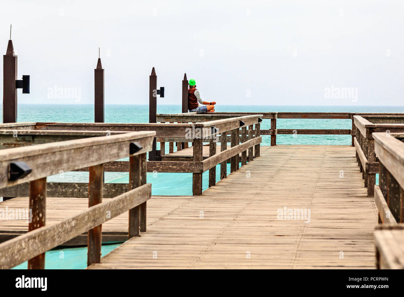 Meditieren einzelner Mann auf der Pier, die Küste der Deutschen Kolonialstadt Swakopmund, Namibia Stockfoto